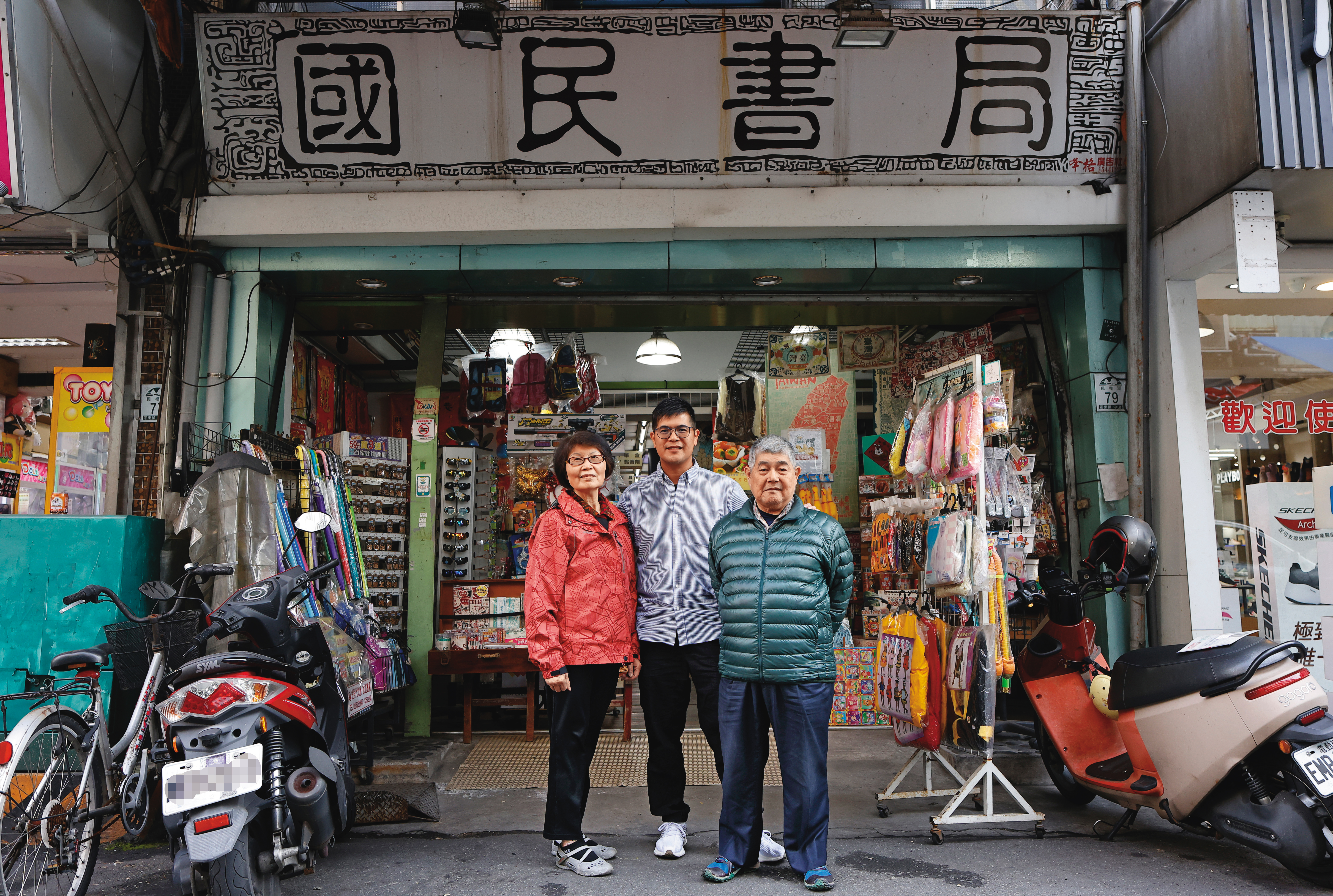 國民書局老闆林勝裕（右）、老闆娘陳碧蘭（左），二代老闆林毓倫（中）積極接班，摸索轉型的路。