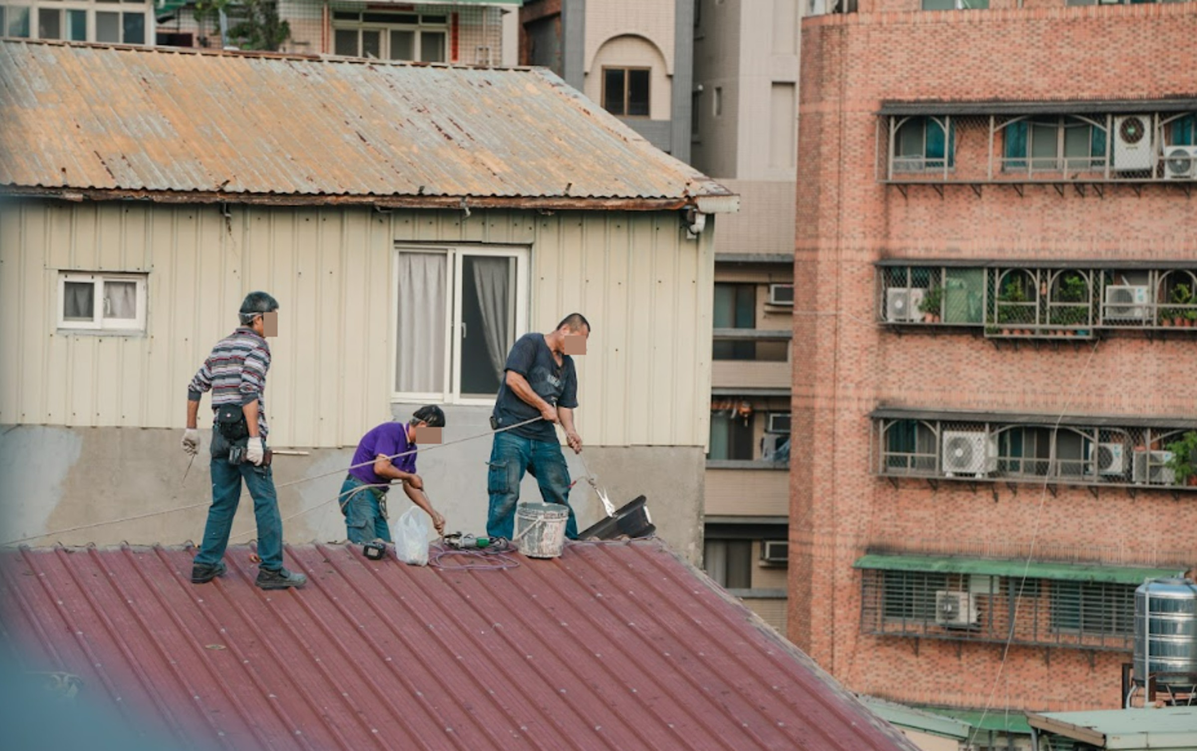 張家自行僱人拆除之際，高空作業的拆除人員竟然沒有配戴安全帽、綁安全繩。（台北市議員林亮君辦公室提供）