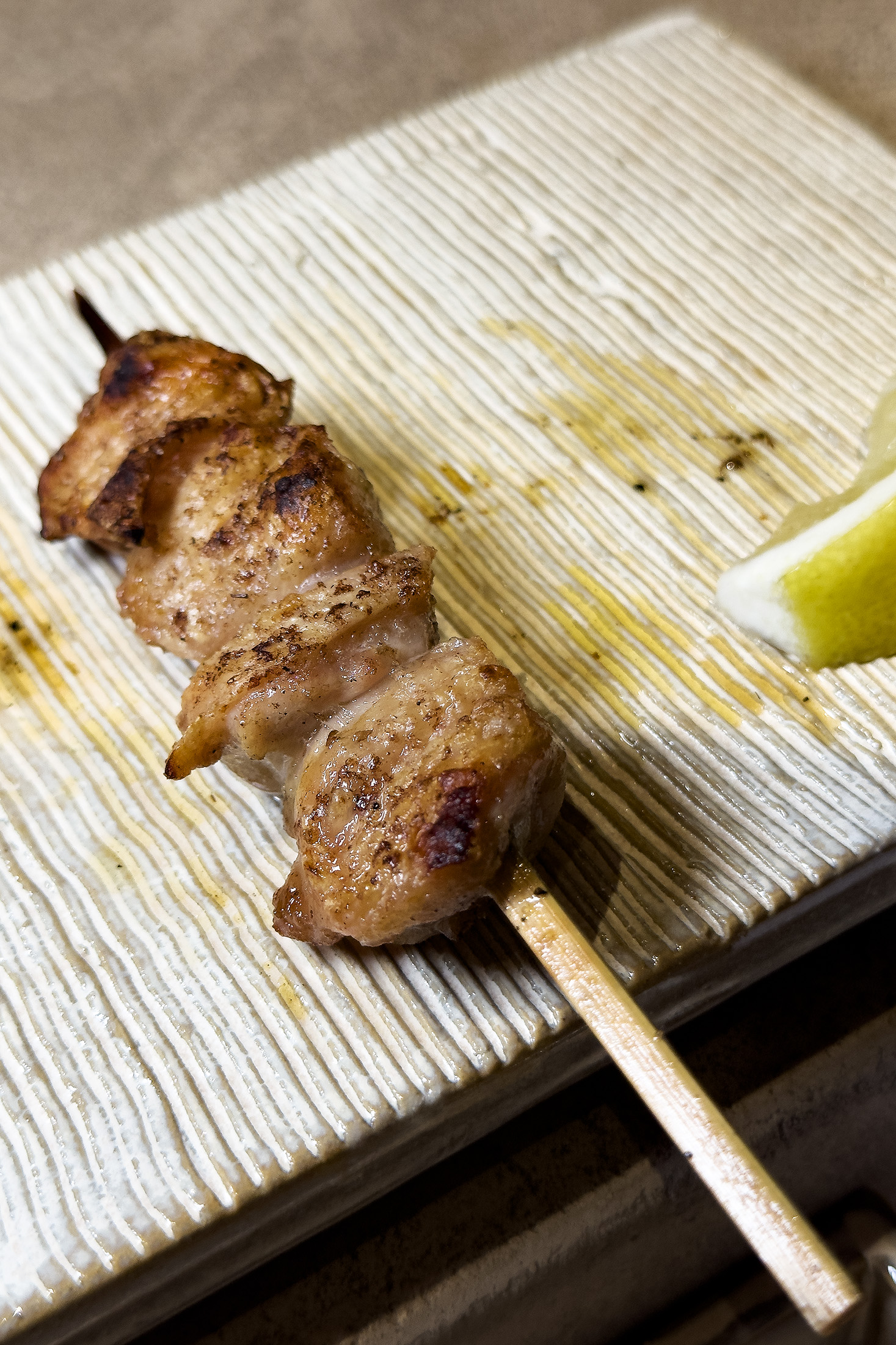 「七里香」在火上緩慢逼出油脂，邊緣微焦酥脆，入口帶黏唇膠質感，炭香與脂香在口中久久不散。