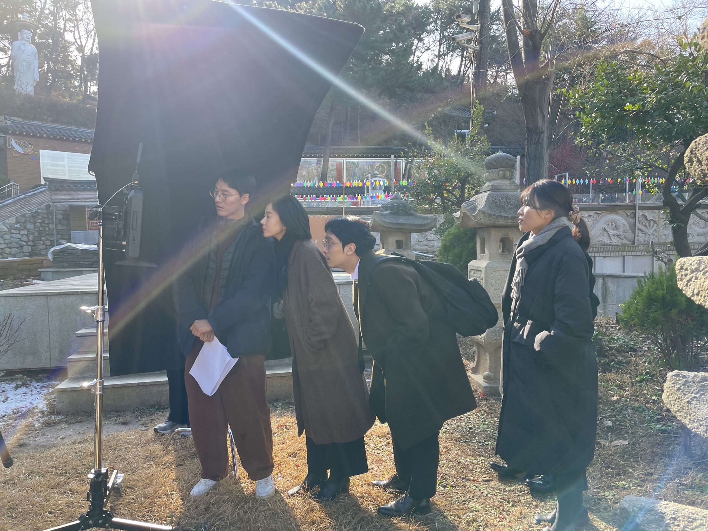 導演金太陽（左起）與演員李明河、夏成國在拍攝現場一起確認畫面。（東昊影業提供）