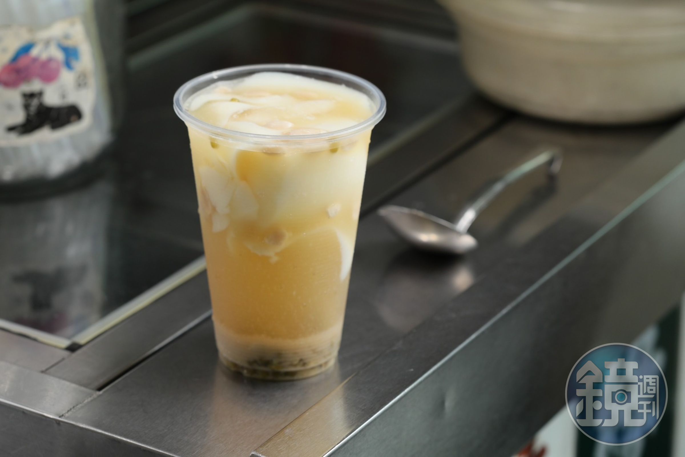 除了內用碗裝，豆花也可以如手搖飲般裝杯外帶，不少學生放學後就來帶上一杯。（圖中品項為百香果豆花加綠豆，25元／杯）