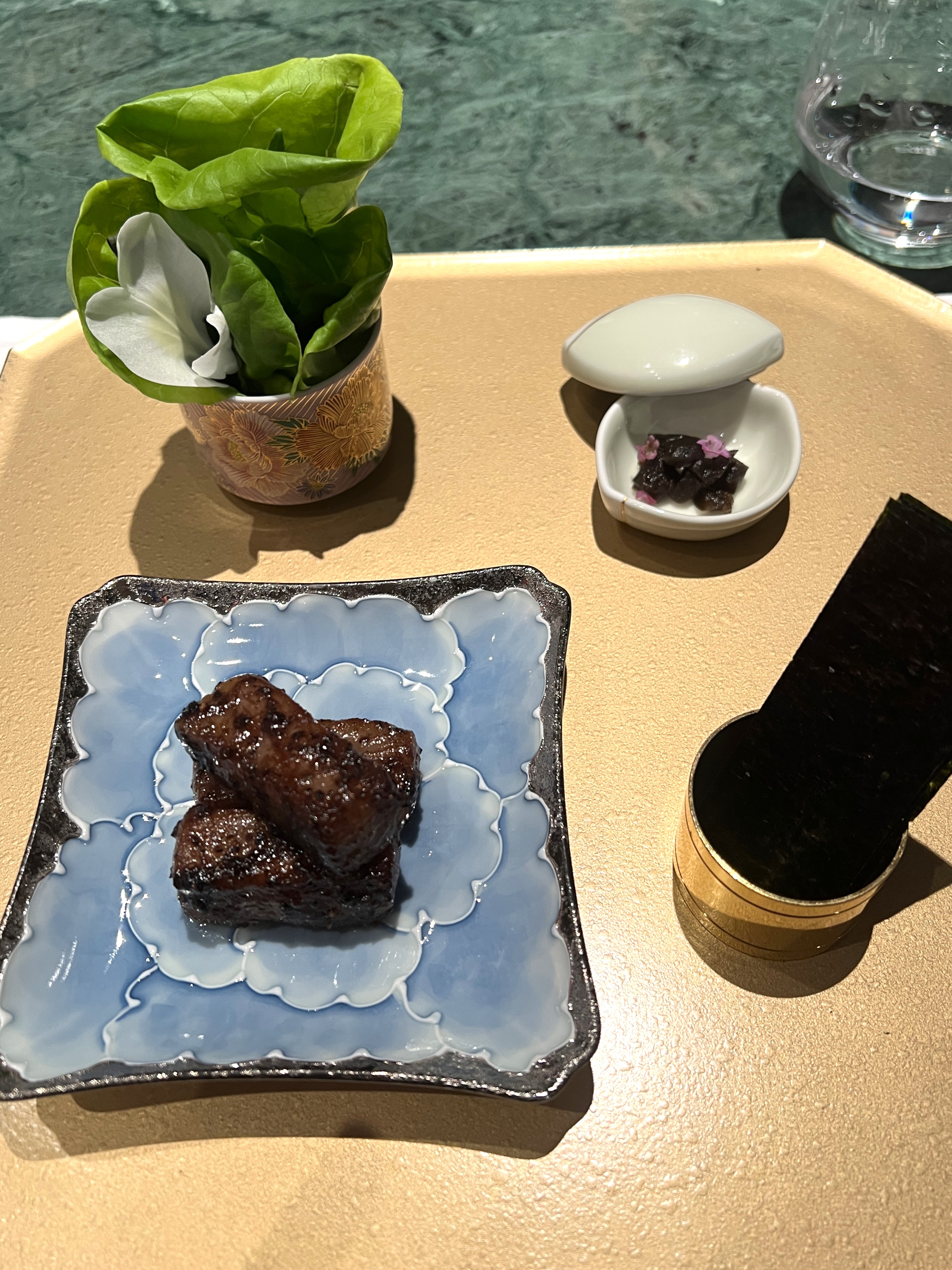 「黑椒、和牛」將和牛加入以蔥、薑、八角、桂皮、蒜頭、辣椒等調和成的香料油，低溫油封入味，搭配馬告黑胡椒醬汁，以及昭和菜、奶油白菜、野薑花和日本百年丸山海苔，還有自製陳年紫蘇梅。