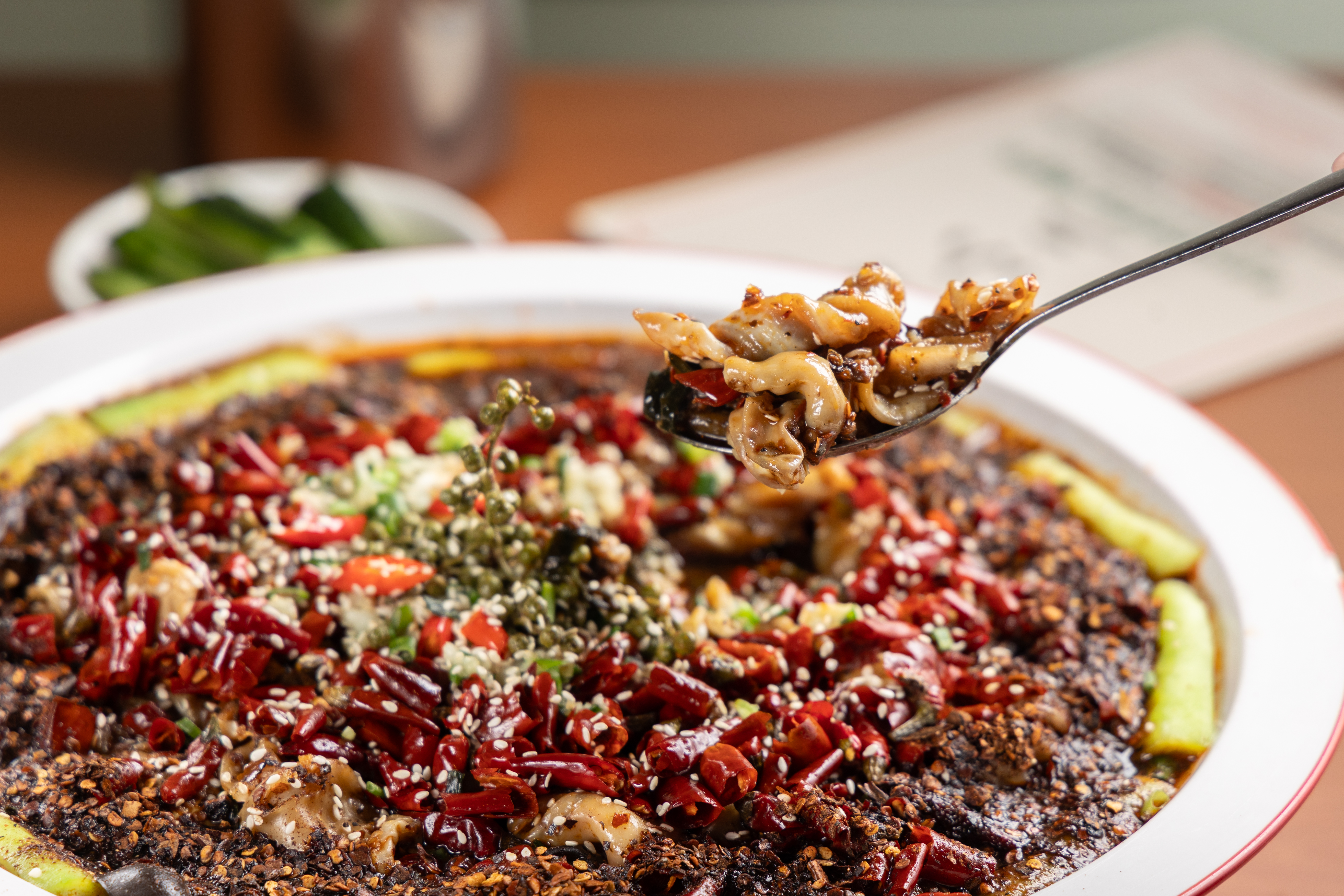 「店小二」的招牌菜「小二秘制麻辣鯇魚卜」，鯇魚鰾吸飽辣汁，雖然辣到想噴火，卻又捨不得那股香辣滋味。（港幣268元／份，約NT$1,011）