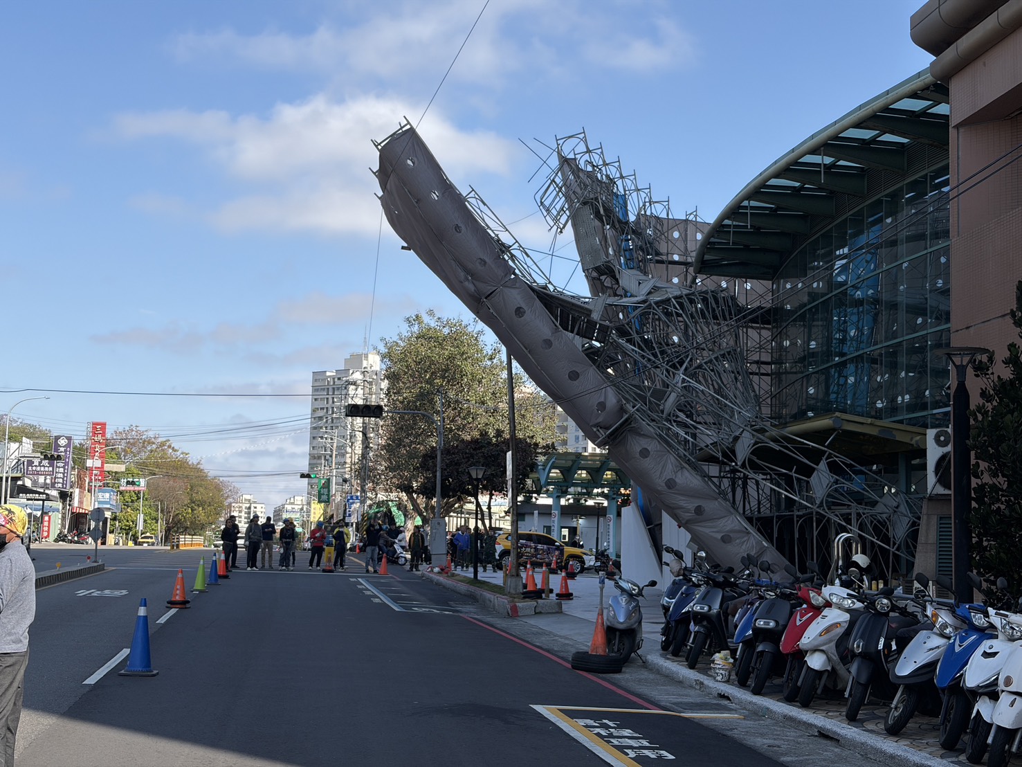 台中榮總外圍鷹架今日清晨不敵強風吹拂，應聲傾斜倒榻，嚇壞路過民眾。（翻攝畫面）