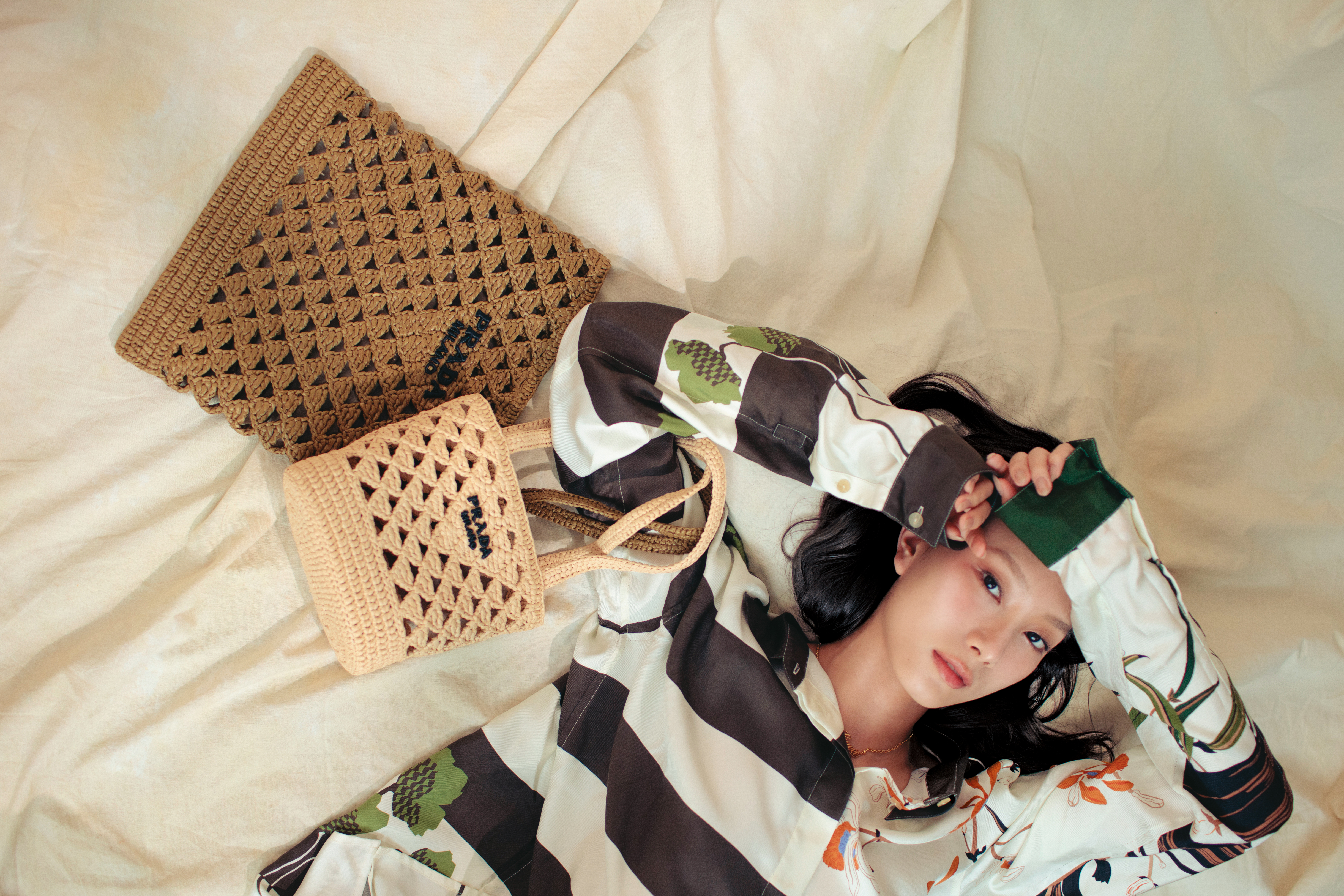 （上）橄欖綠鉤織托特包 NT$63,000 by PRADA／（下）鉤織手提包 NT$57,000 by PRADA／印花真絲襯衫 NT$70,000 by LOEWE／GUCCI LOGO項鍊 NT$18,800 by GUCCI