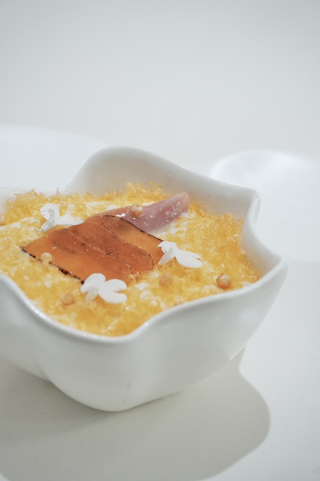 發想自瑞士起司鍋的「烏⿂⼦乳酪燴⿃⾙」，在刷上起司界的烏魚子「Mimolette」後鋪上新竹野生烏魚子薄片，吃起來鹹鮮潤口，暖意十足。