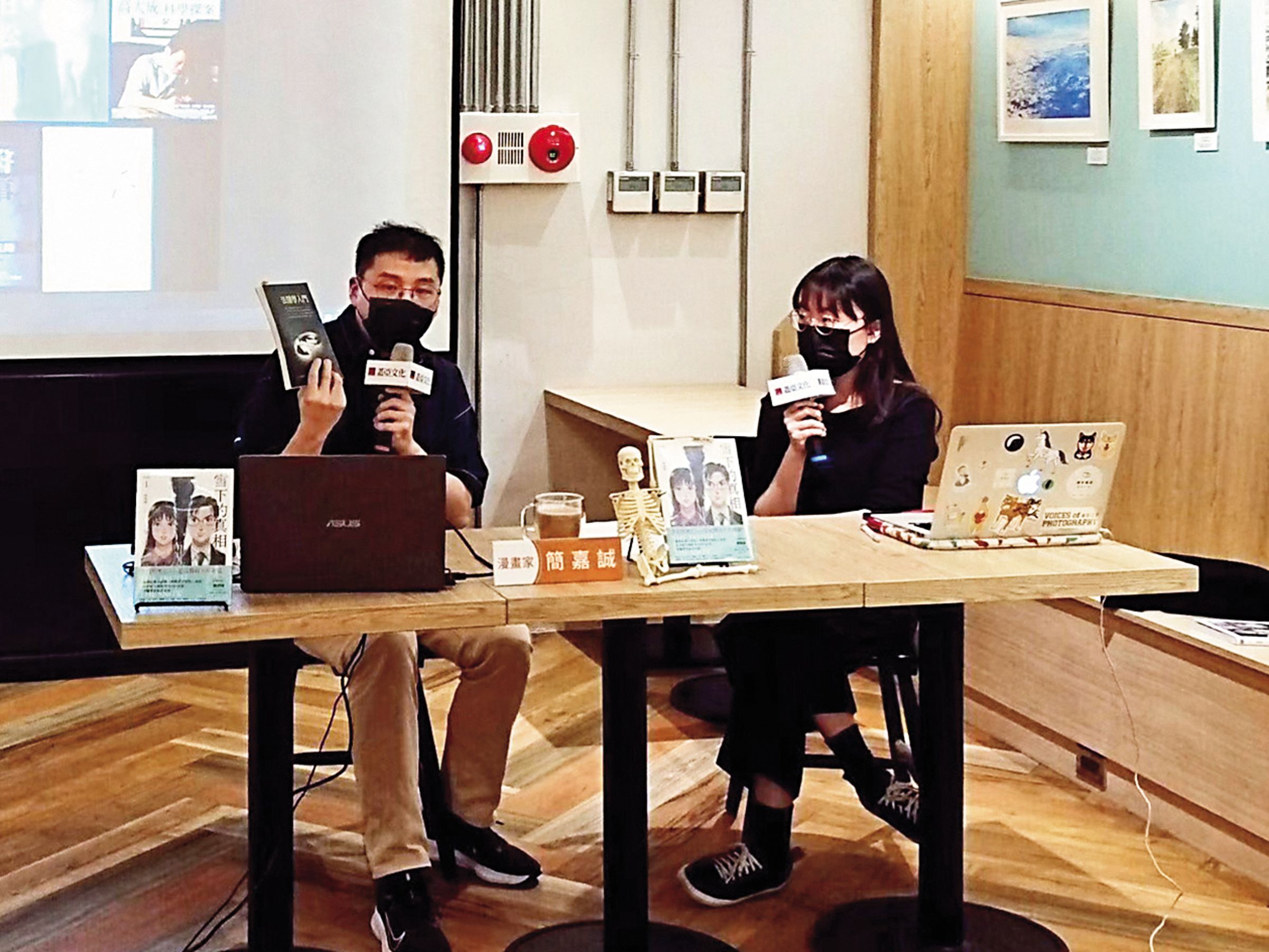 簡嘉誠(左)在《雪下的真相》新書分享現場,介紹參考取材的法醫相關書籍。(蓋亞文化提供)