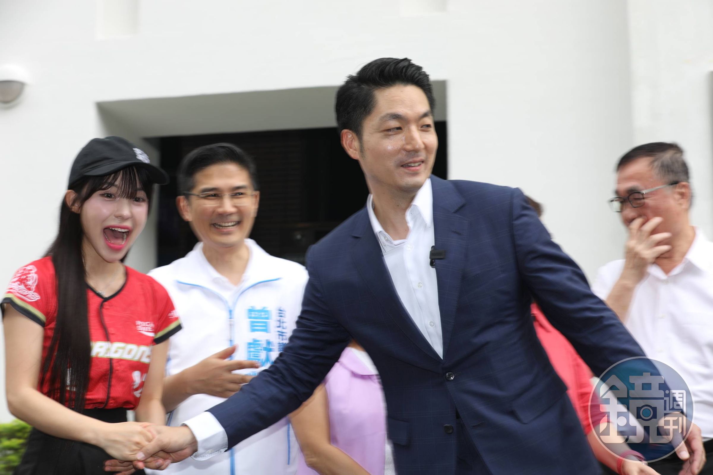 蔣萬安在青年局外揭牌合影時，主動牽著李多慧的手把他帶到C位同框。