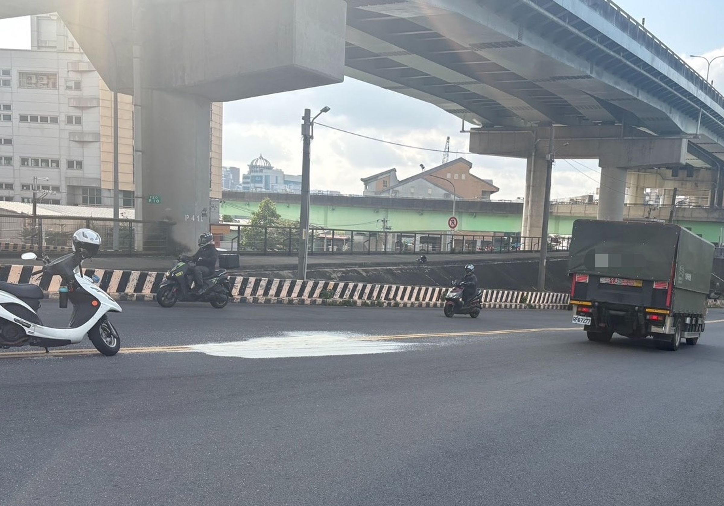 位在新北市三重區9號越堤道下坡往疏洪十路方向，路面有一攤白米，導致劉姓騎士輾過當場自摔倒地。（翻攝畫面）