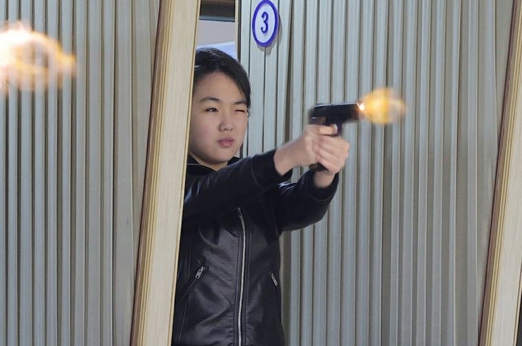 金主愛穿一身黑色皮衣，神情專注扣下扳機，槍口火光瞬間噴出。（翻攝《朝中社》）