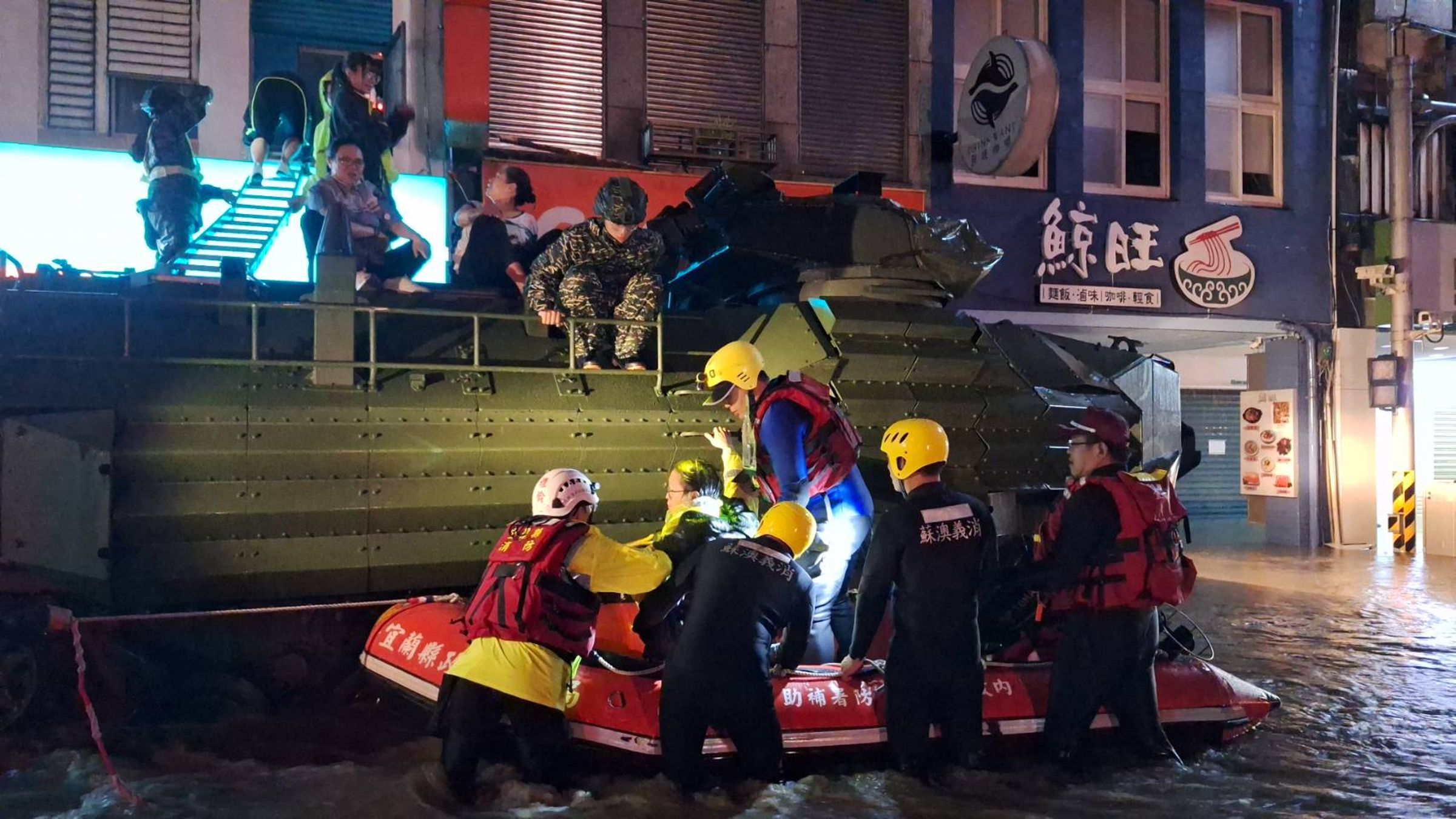 AAV7軍用兩棲車搭配鋁梯以及橡皮艇,協助受困二樓的民眾脫困。(翻攝自蘇澳鎮公所臉書)