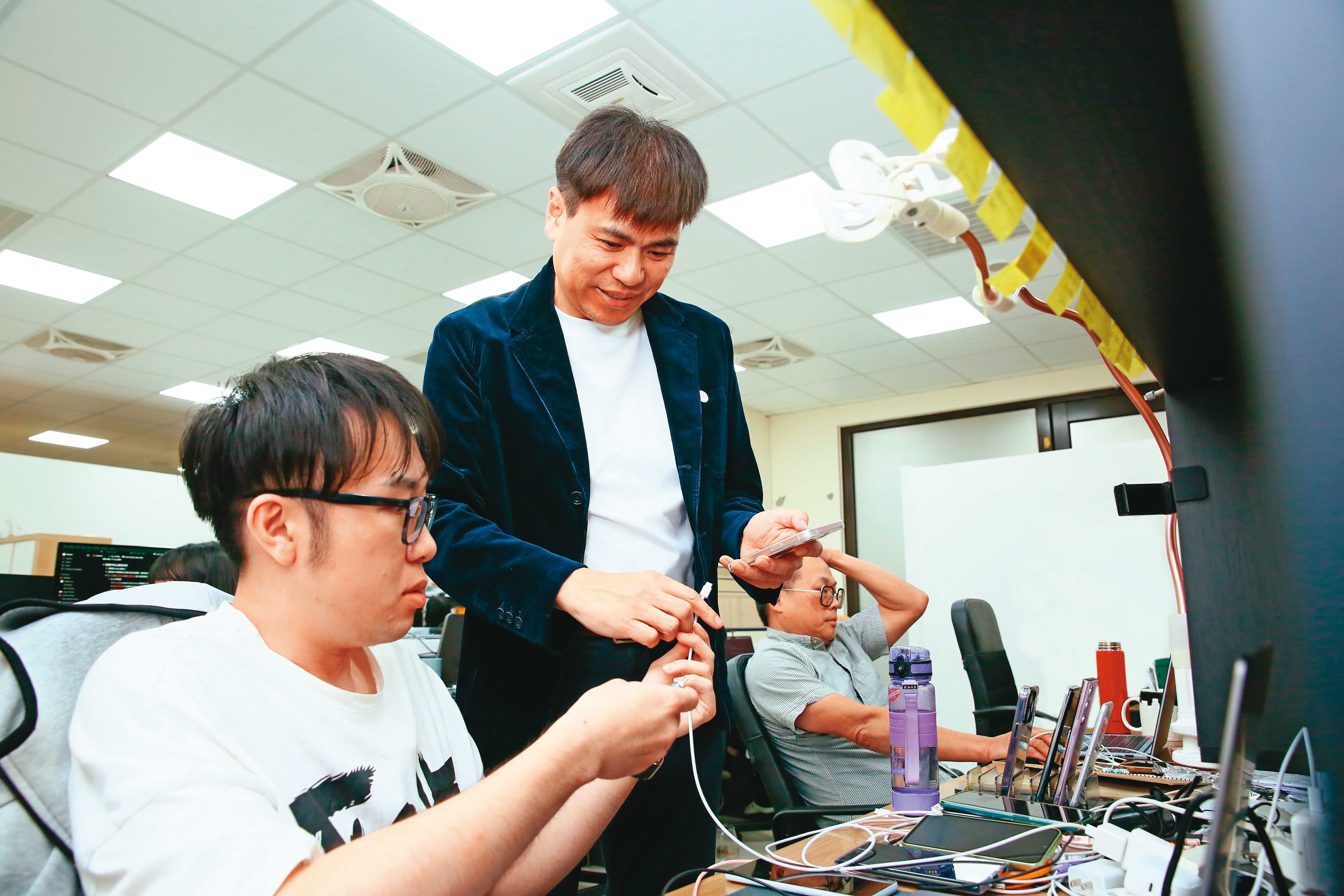圖中站立者為陳良信,為了讓自家產品在Android系統上也能使用,他測試遍了市面上所有大品牌手機。