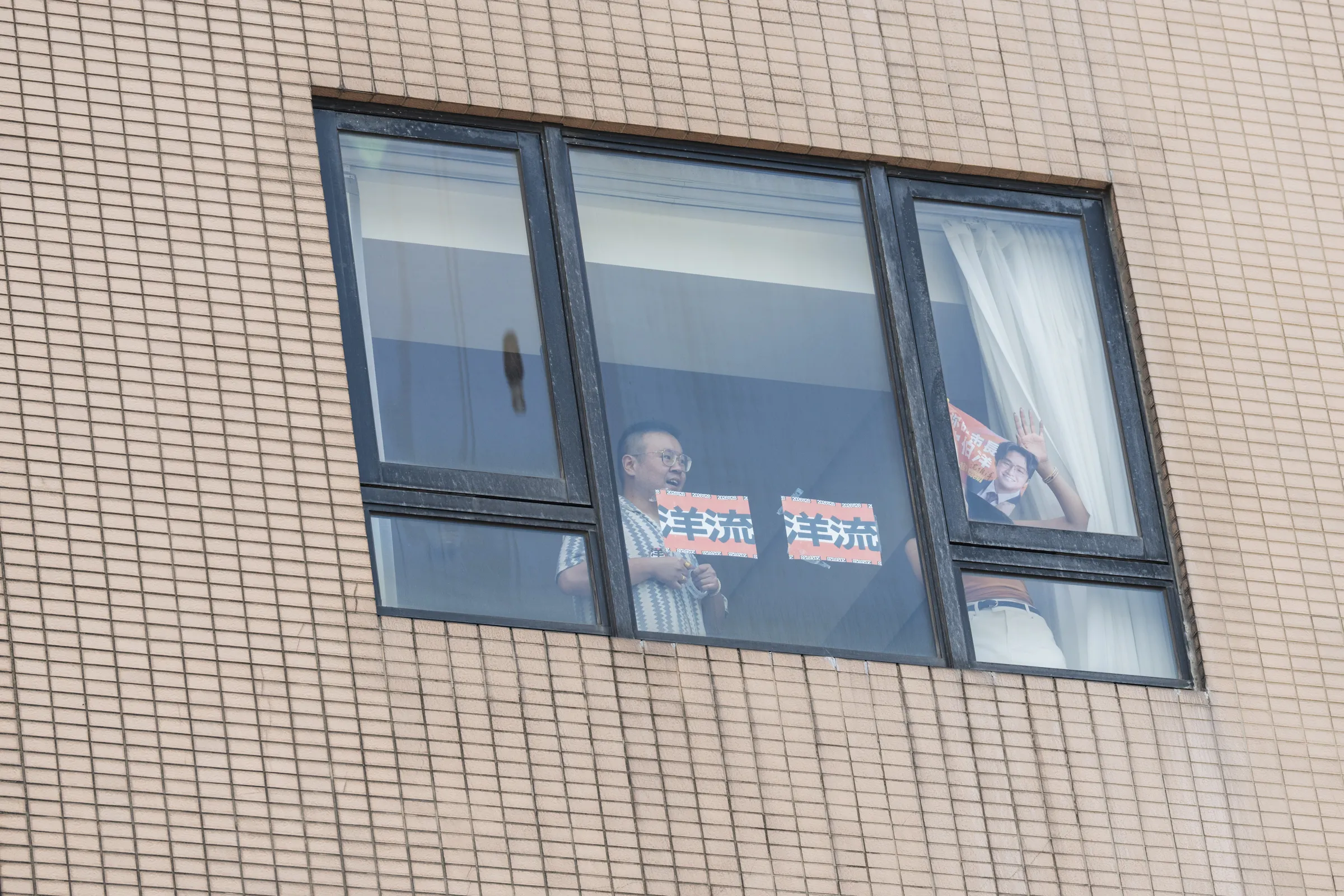 民進黨台北市長候選人沈伯洋日前舉辦造勢大會，不少支持者特別訂下沿路旅館房間，隔著窗戶舉起「洋流」海報應援，創意方式引發網友熱議。