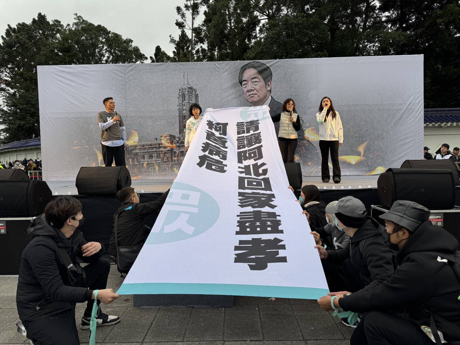 柯美蘭與陳佩琪舉起布條齊喊「柯爸病危，請讓阿北回家盡孝」。