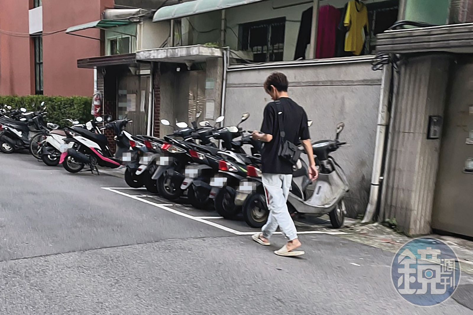 5/14,18:00,傍晚時分,阿翔穿拖鞋從台北市東區家中步出,邊走邊看手機。(讀者提供)