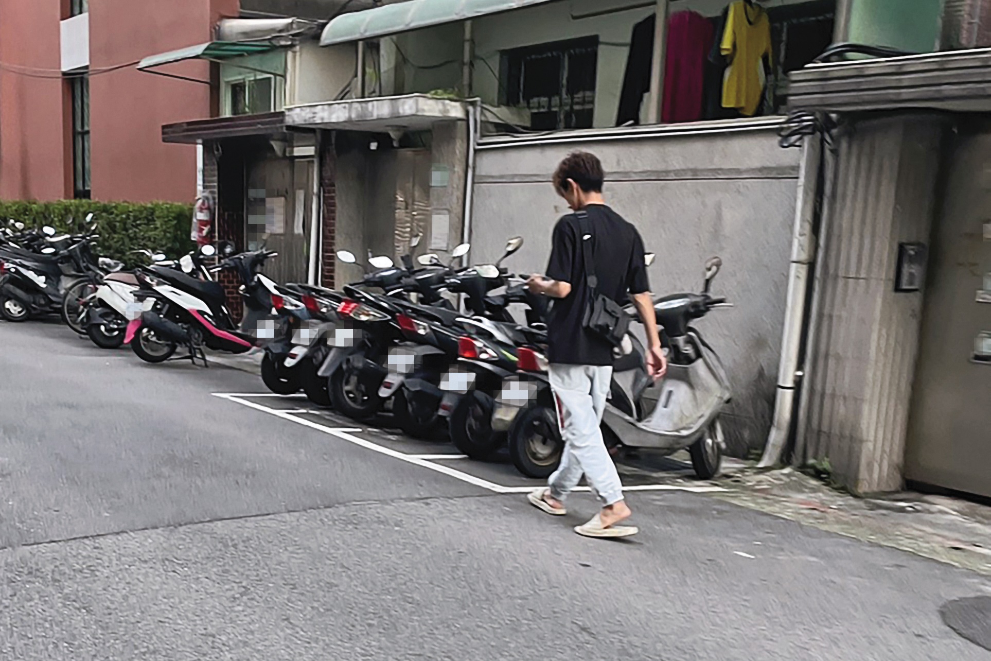 5/14，18:00，傍晚時分，阿翔穿拖鞋從台北市東區家中步出，邊走邊看手機。（讀者提供）
