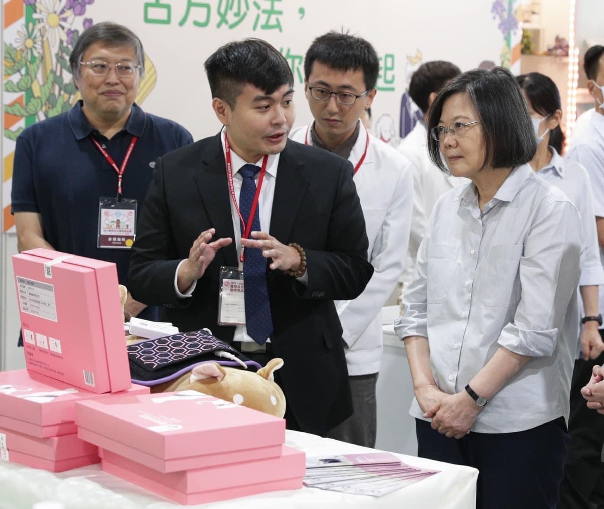 相當關注寵物長照議題的蔡英文，在寵物展上認真地聽能光能墊的用途。（寵樂動物醫院提供）