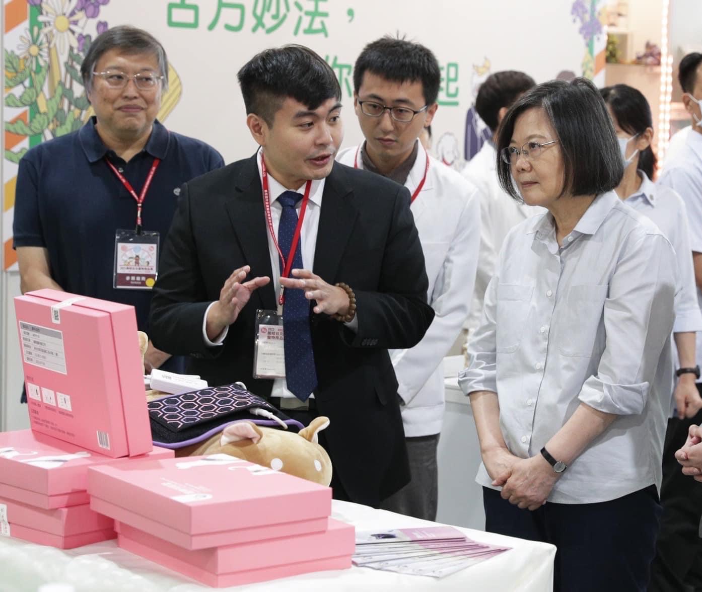 相當關注寵物長照議題的蔡英文，在寵物展上認真地聽能光能墊的用途。（寵樂動物醫院提供）