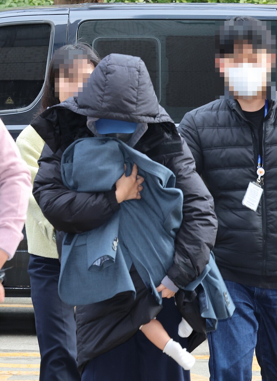 涉嫌恐嚇韓星李善均並拿到5,000萬元的28歲A女,今(28日)抱著小孩現身韓國仁川地方法院。(翻攝newsis網站)