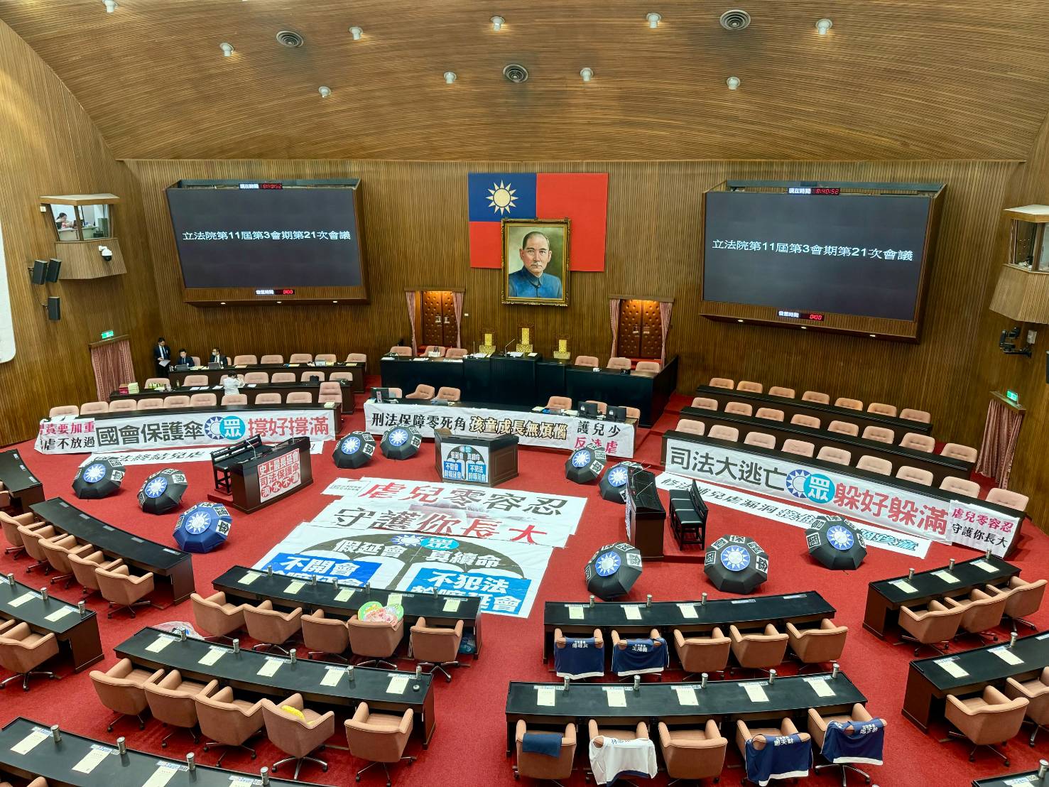 朝野今在議場高舉布條攻防,最終在藍白人數優勢下通過延會提案。(鏡報林煒凱攝)