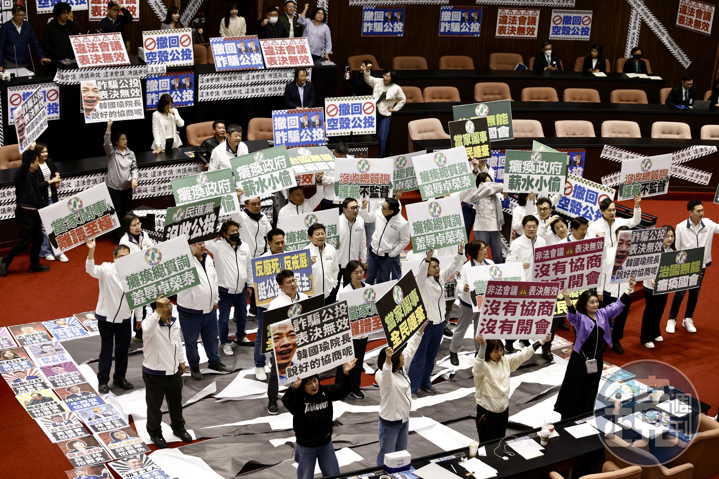 議場上除了貼著滿滿的標語,綠委也舉牌反對藍白公投。