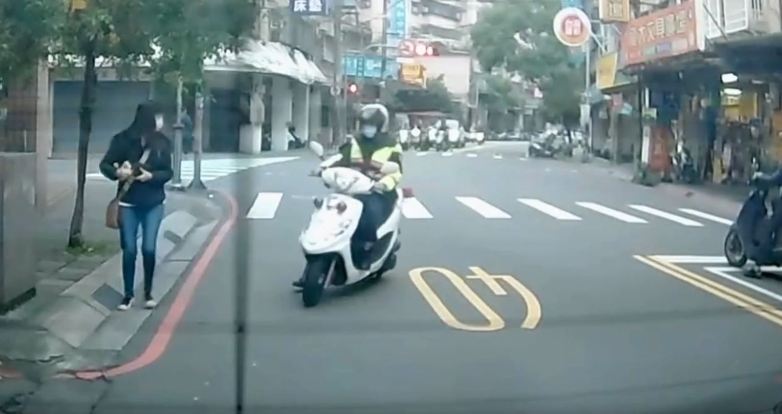 有位女子過馬路時因交通違規,被警察開單。(翻攝自爆料公社)