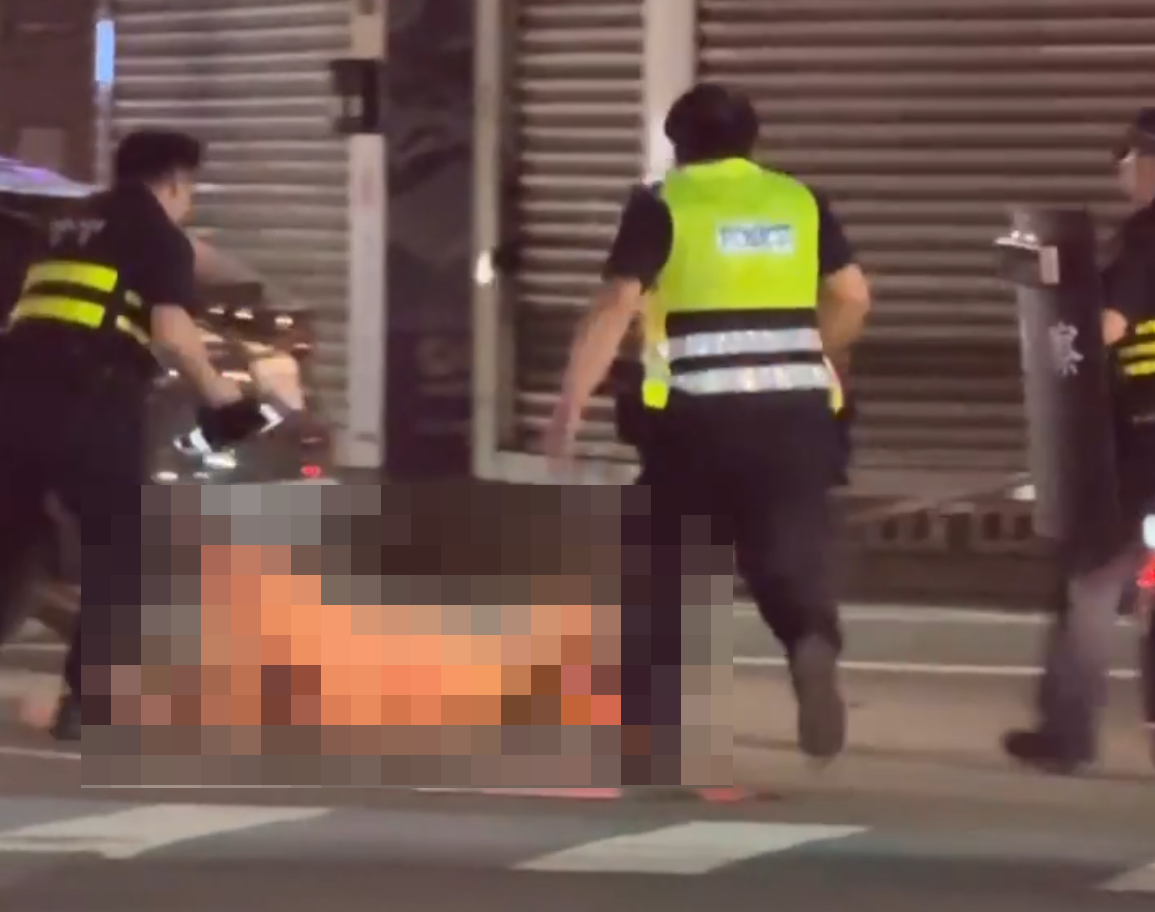 張姓男子弒母之後全裸逃至大街，警方到場使用辣椒水將他制伏。（翻攝畫面）