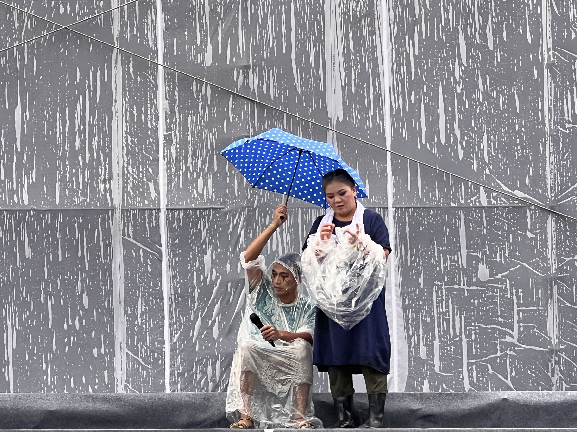副團長莊瓊如在雨中撐傘彩排。(紙風車提供)