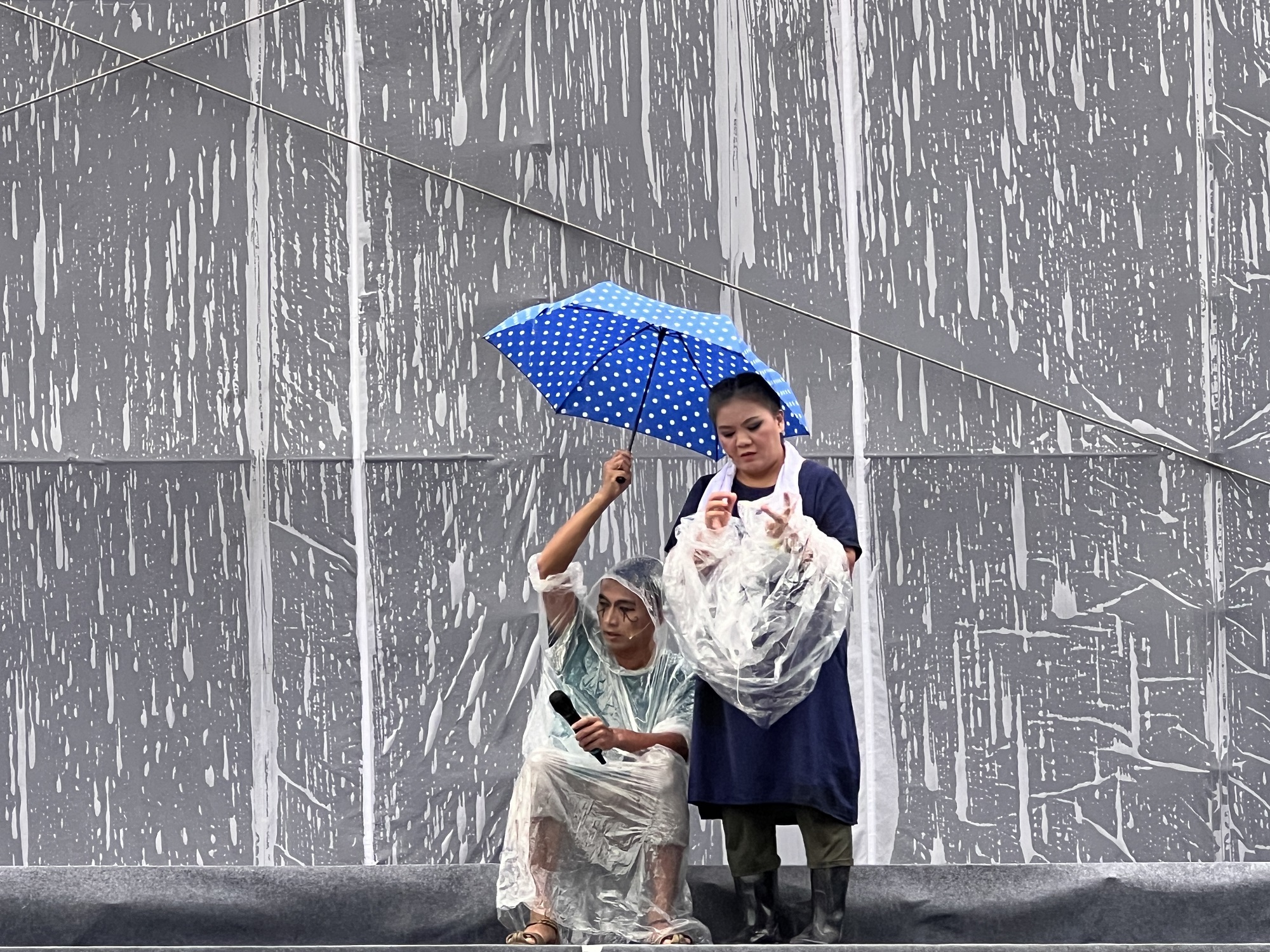 副團長莊瓊如在雨中撐傘彩排。（紙風車提供）