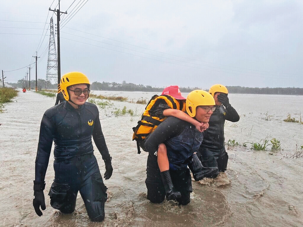 南台灣暴雨導致大淹水，消防隊員冒險涉水救出受困者。（屏東消防局提供）