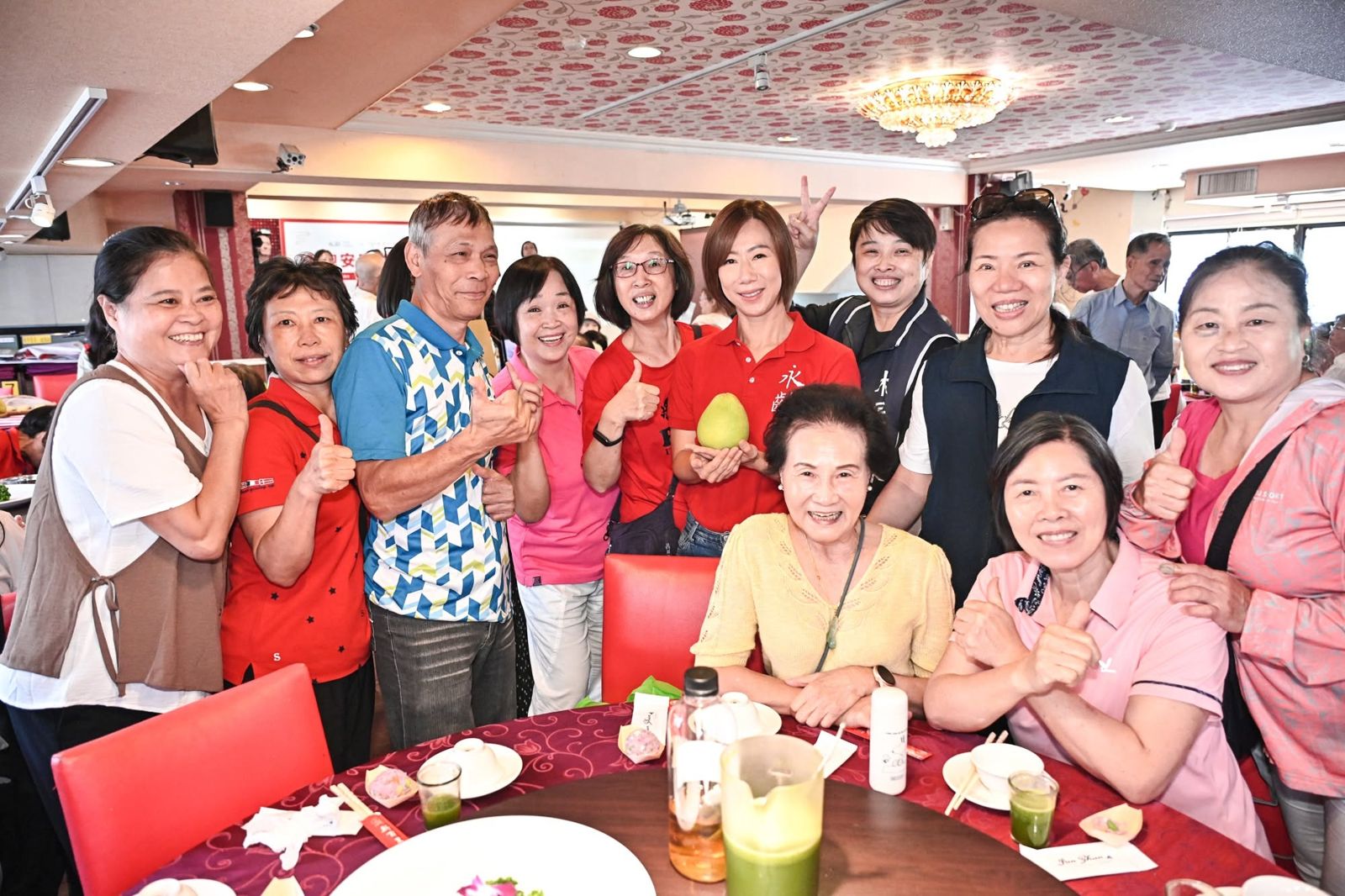 郭曉玲（後排右4）與長輩合影，並推廣集結50道營養料理的《美味食記》。（翻攝永齡基金會臉書）