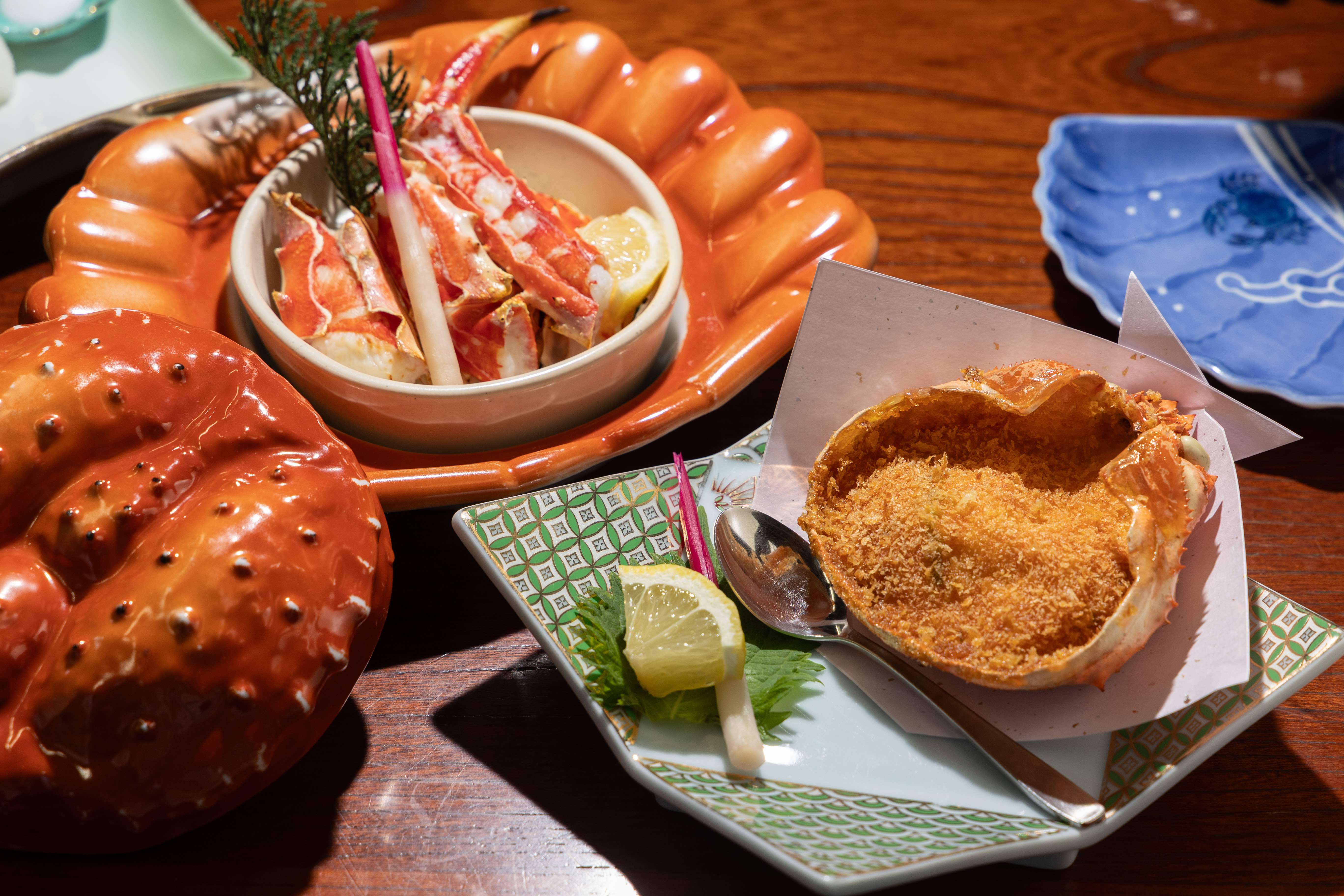 「本タラバかに宝楽焼き」（左，5,300日圓／個，約NT$1,036）使用寶樂燒連殼燒烤帝王蟹；「特撰かに甲羅揚げ」（右，1,650日圓／個，約NT$323）將蟹肉、魚漿、蝦漿混合後油炸。