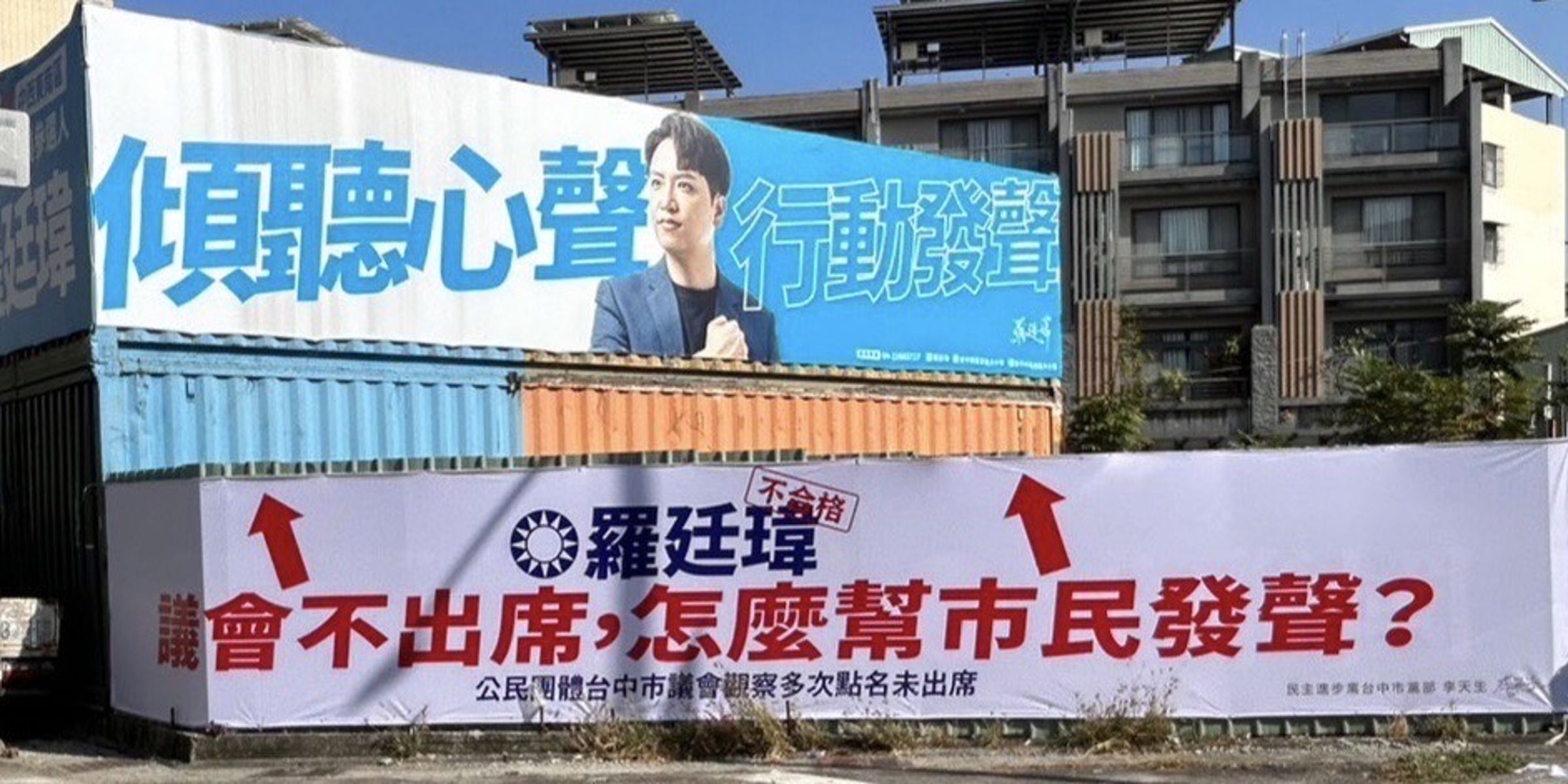 民進黨台中市黨部掛上看板，質疑國民黨立委候選人羅廷瑋是「薪水小偷」。（翻攝畫面）