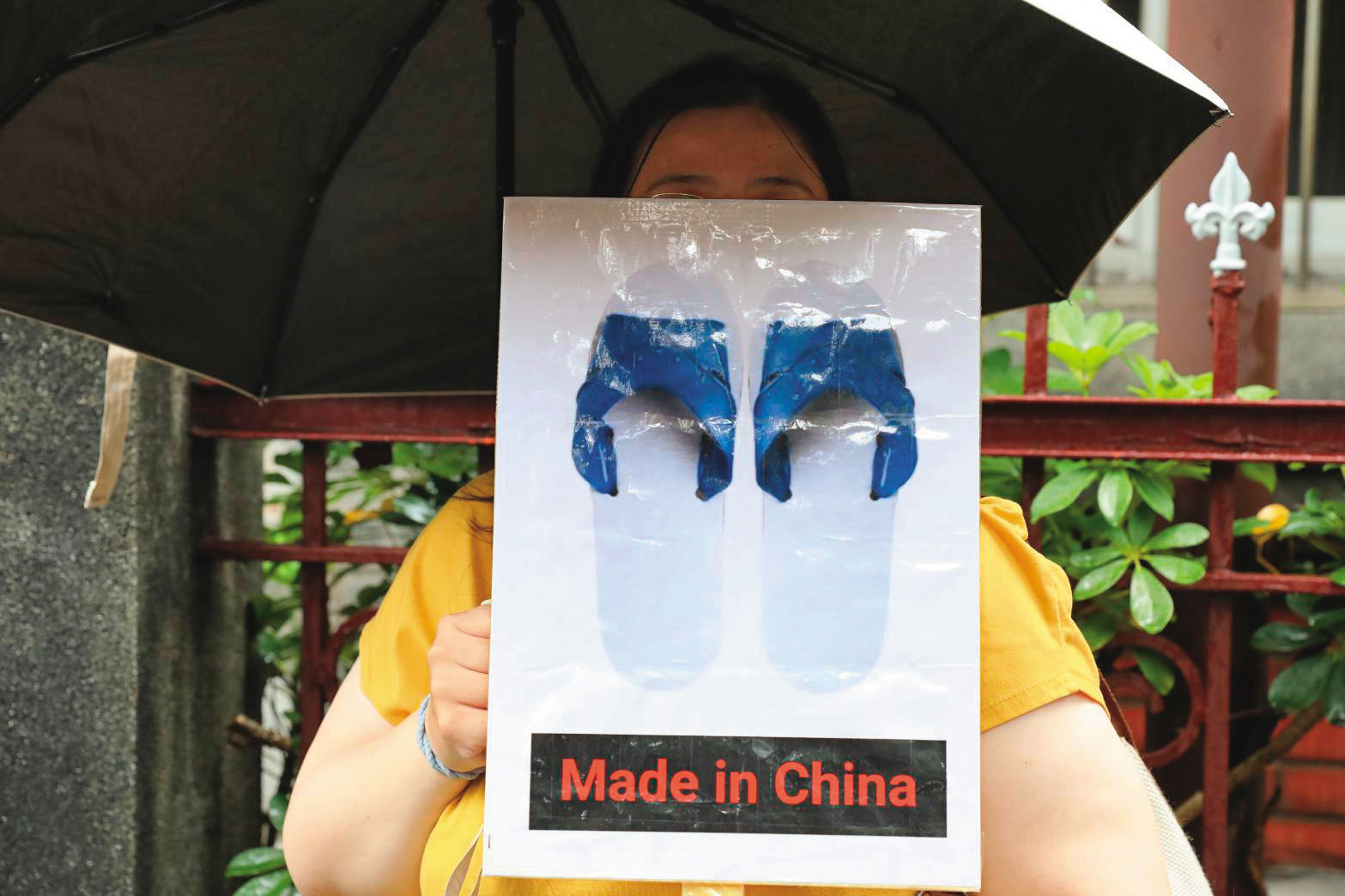 民眾手持藍白拖Made in China標語，諷刺藍白陣營跟中國站在一起，拖累台灣。