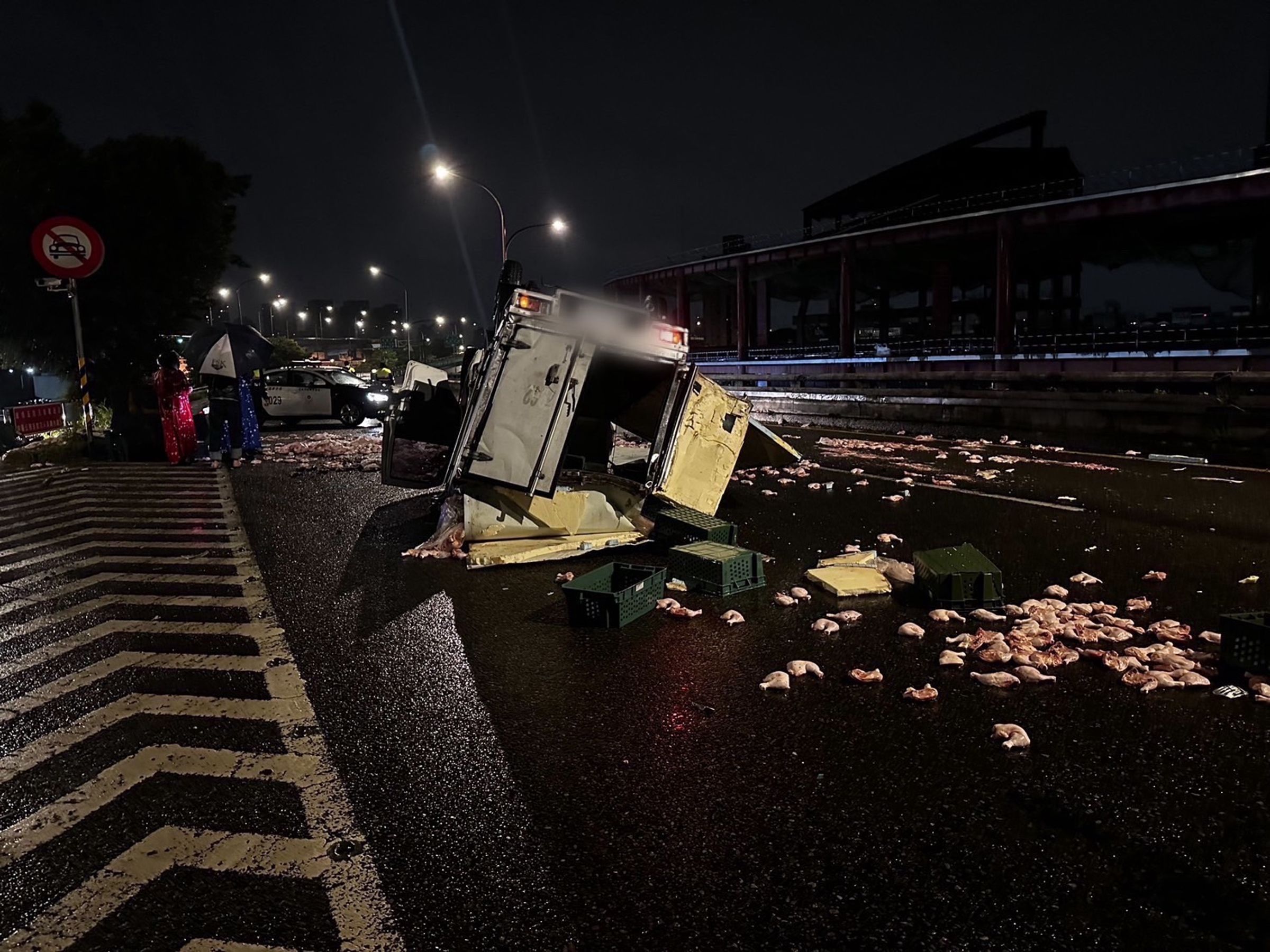 貨車四輪朝天毀損嚴重，生鮮雞腿四散在車道上。（翻攝畫面）