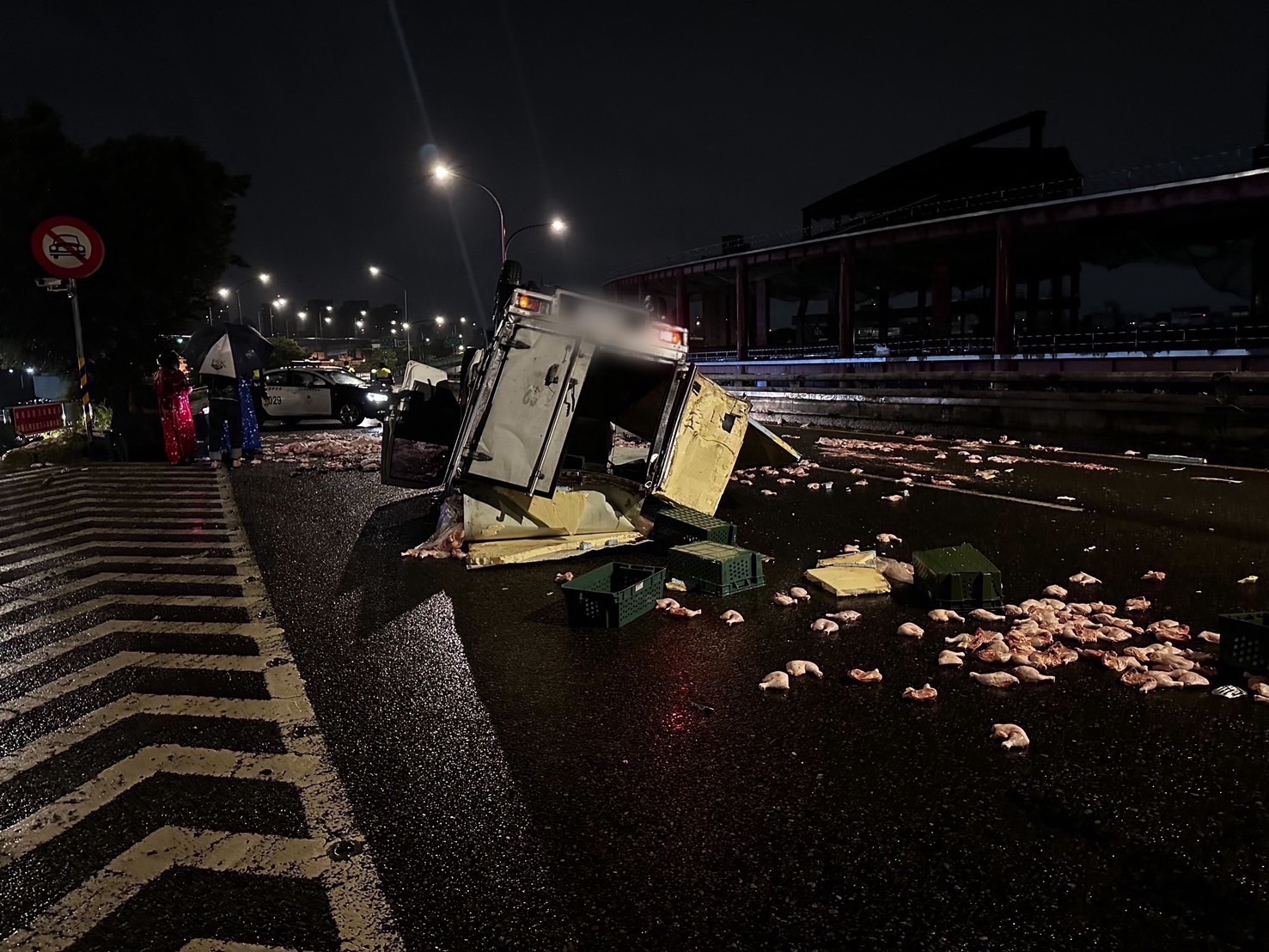 貨車四輪朝天毀損嚴重,生鮮雞腿四散在車道上。(翻攝畫面)