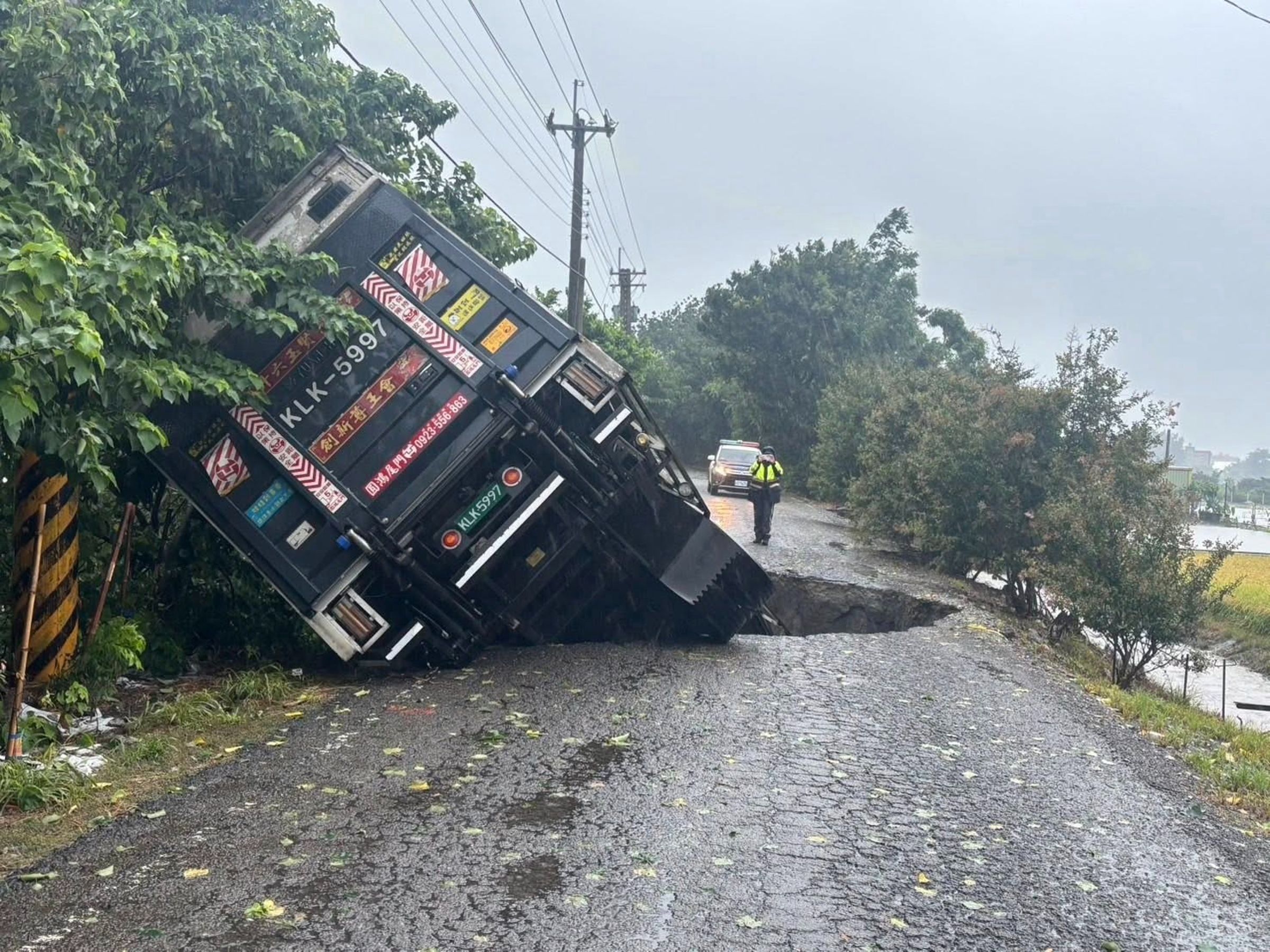 彰化縣二林鎮受強降雨影響，地面出現天坑，大貨車受困動彈不得。（翻攝自彰化縣媒體記者協會）