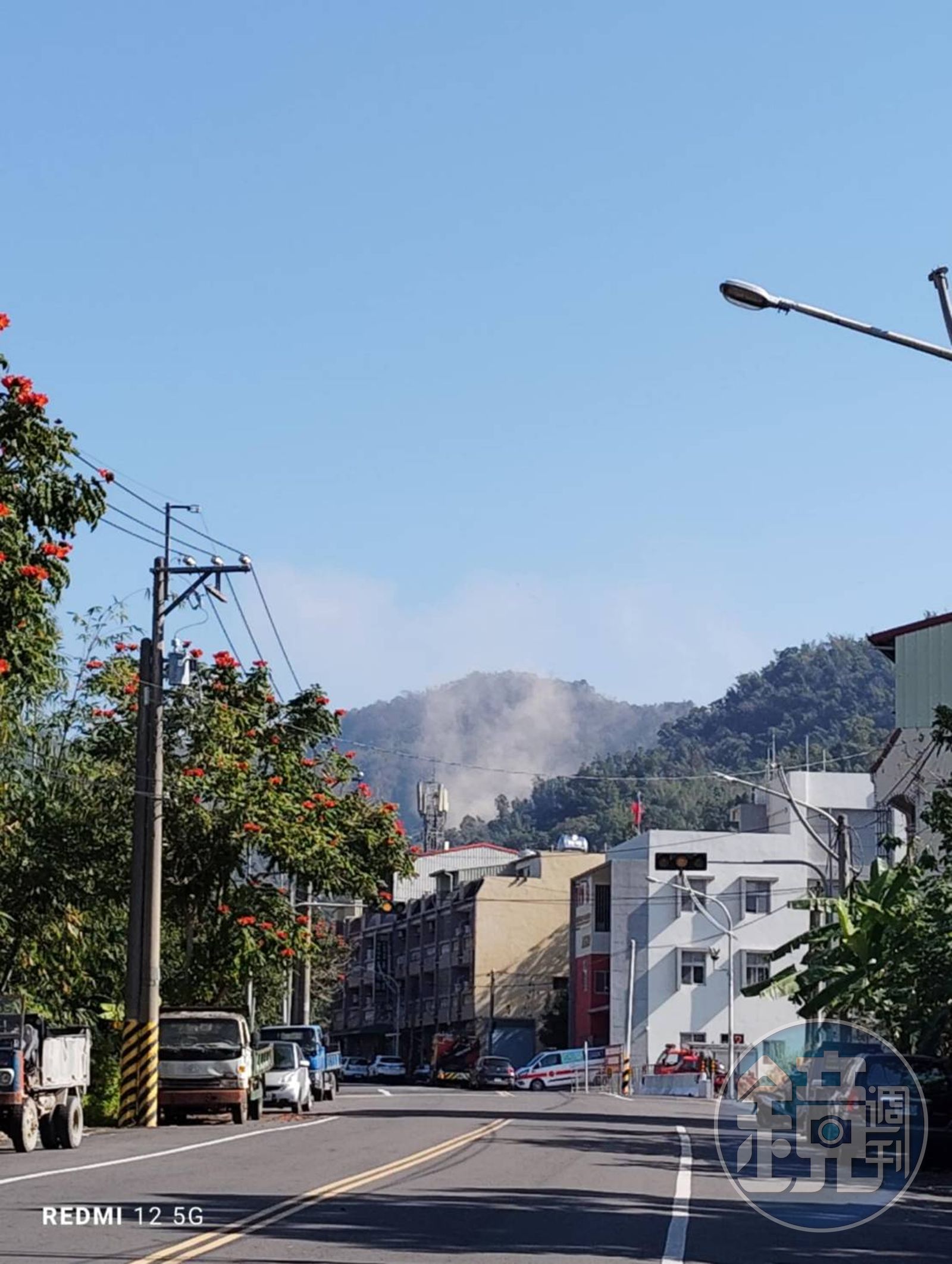 大埔市區土石滑落,遠處可見煙霧。(讀者提供)