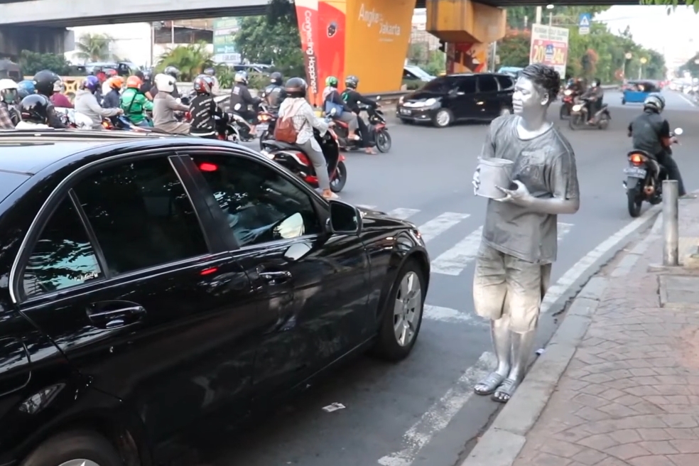 「銀人們」時常赤腳站在路口，向來往的車輛乞討零錢。圖非當事人（翻攝自frengki pasaribu YT）