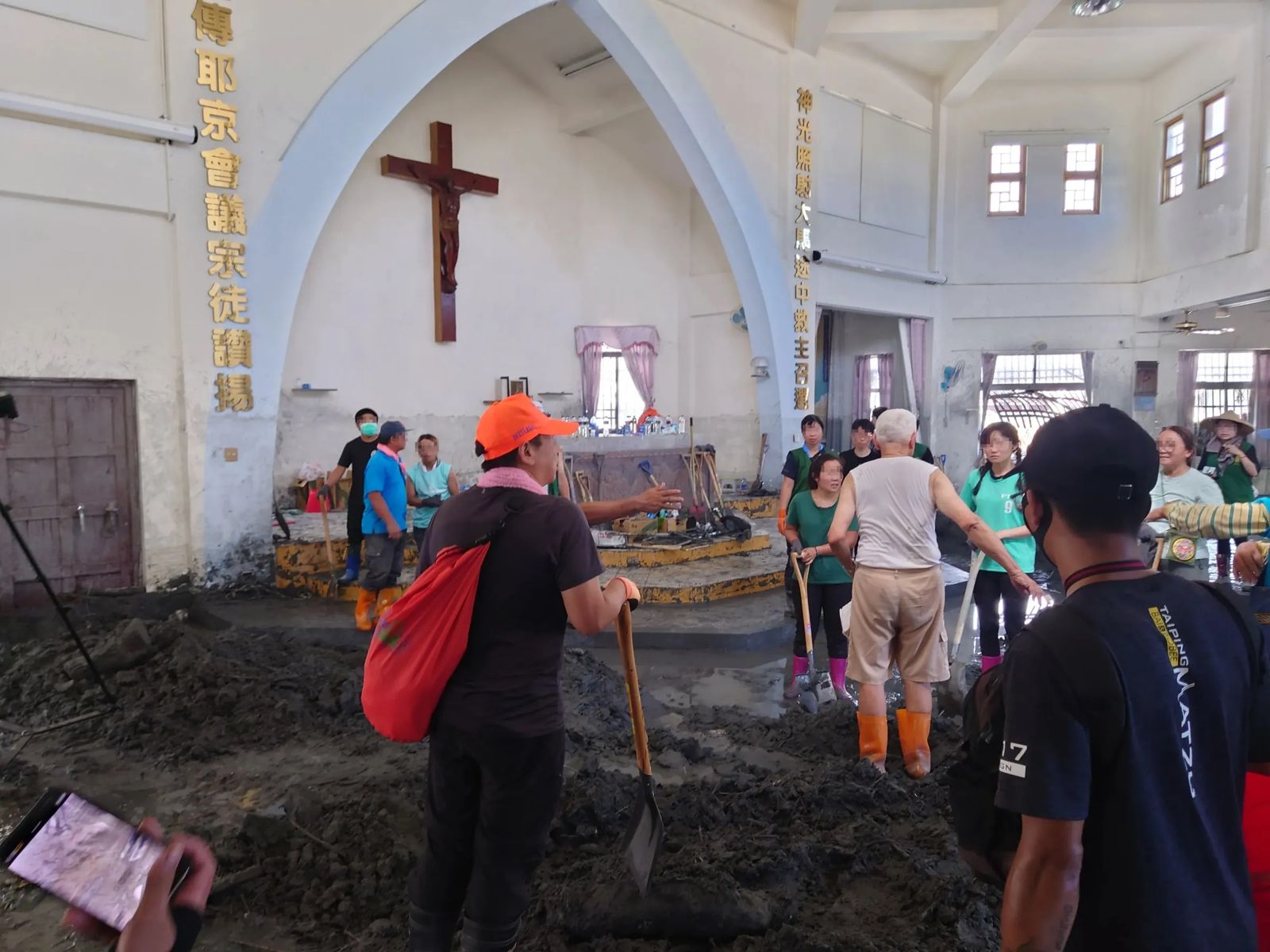信仰佛教、媽祖的鏟子超人齊聚大馬天主堂，圍繞在呂德偉神父身旁，協助救災。（Threads／@tangho.lin 授權提供）