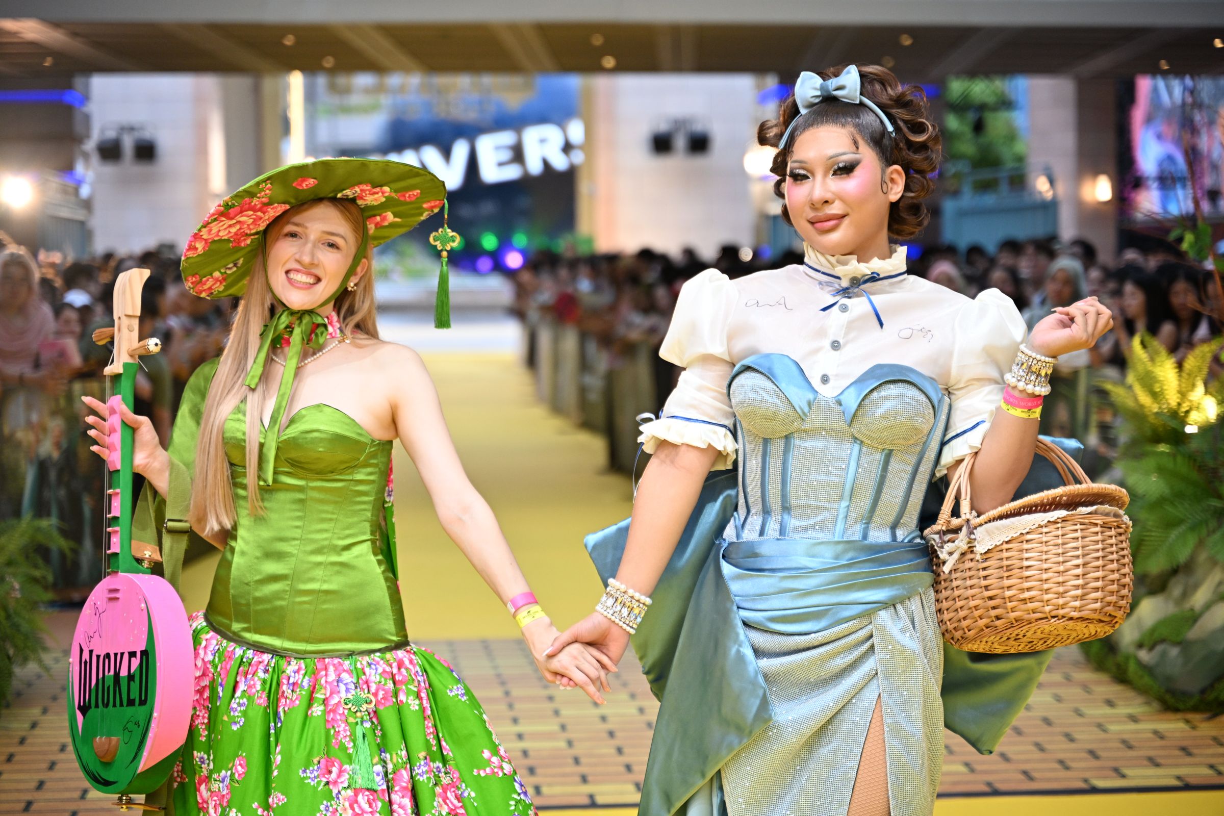 穿上融合象徵奧茲國綠色，與代表台灣客家花布訂製禮服的崔璀璨（左），手上拿著藝術家特製的粉綠雙色月琴，與變莊皇后薔薇（右）的華麗桃樂絲造型，一起踏上《魔法壞女巫：第二部》的星光大道。（UIP提供）