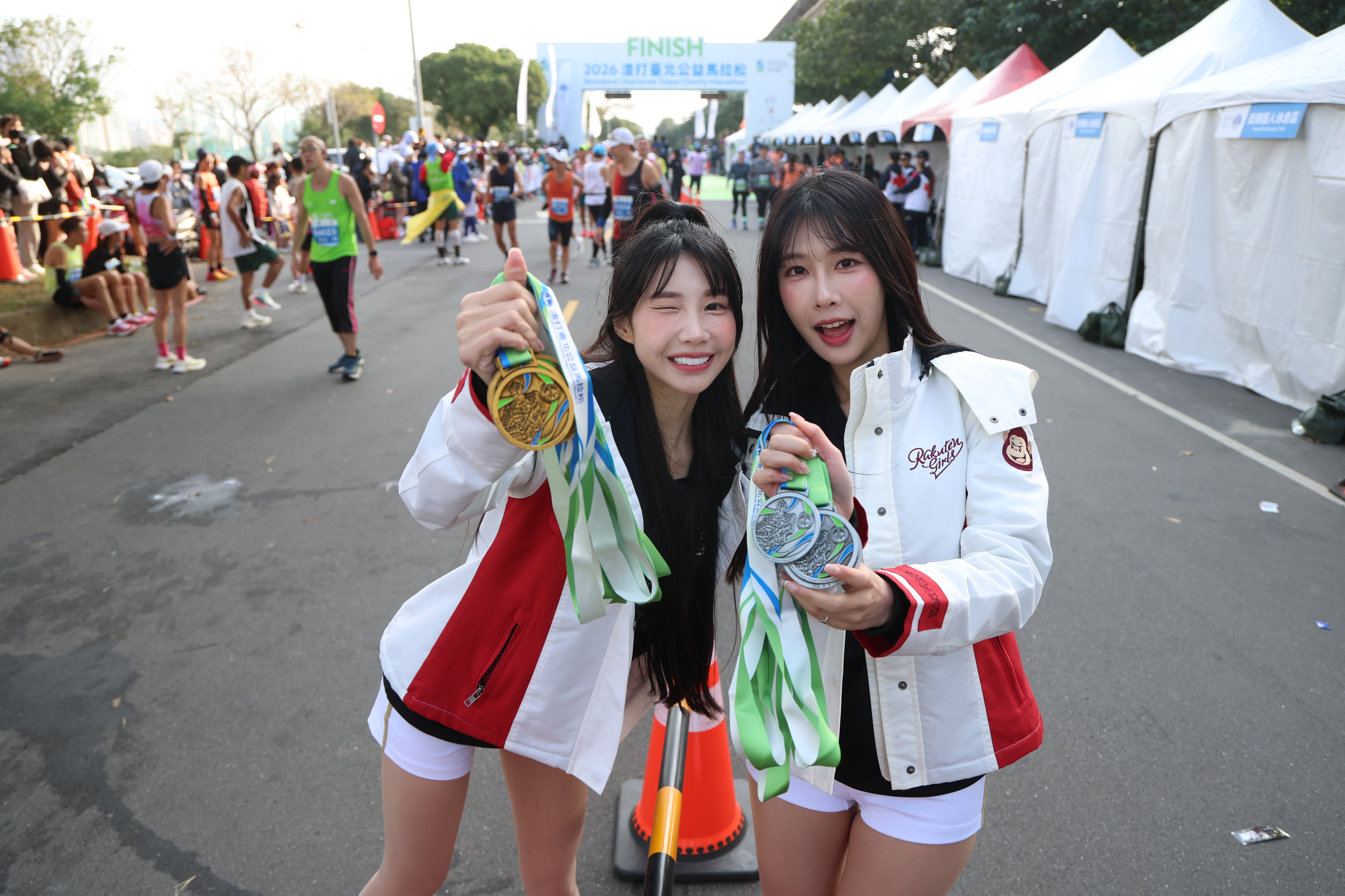 筠熹、Kira頂著低溫為跑者加油打氣。（樂天桃猿提供）