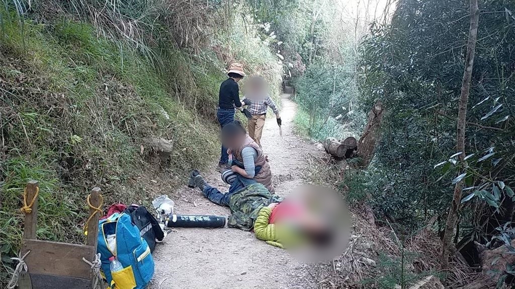 來自台中的民眾21日參加司馬庫斯賞櫻團，吃下預先買好的餐點後出現上吐下瀉的反應，有老翁痛苦的倒在地上等待救援，共計11人送醫。（新竹縣消防局提供）