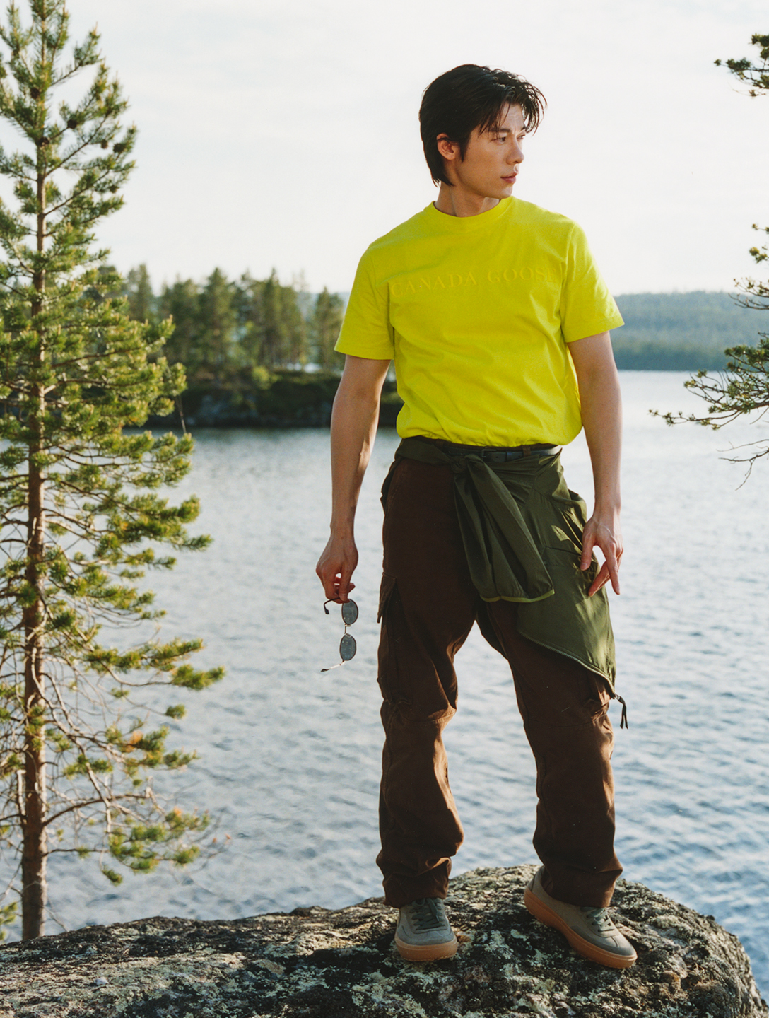 許光漢以亮色的青檸色Vantage T-Shirt，身處在陽光與湖畔景色中。（Canada Goose提供）       