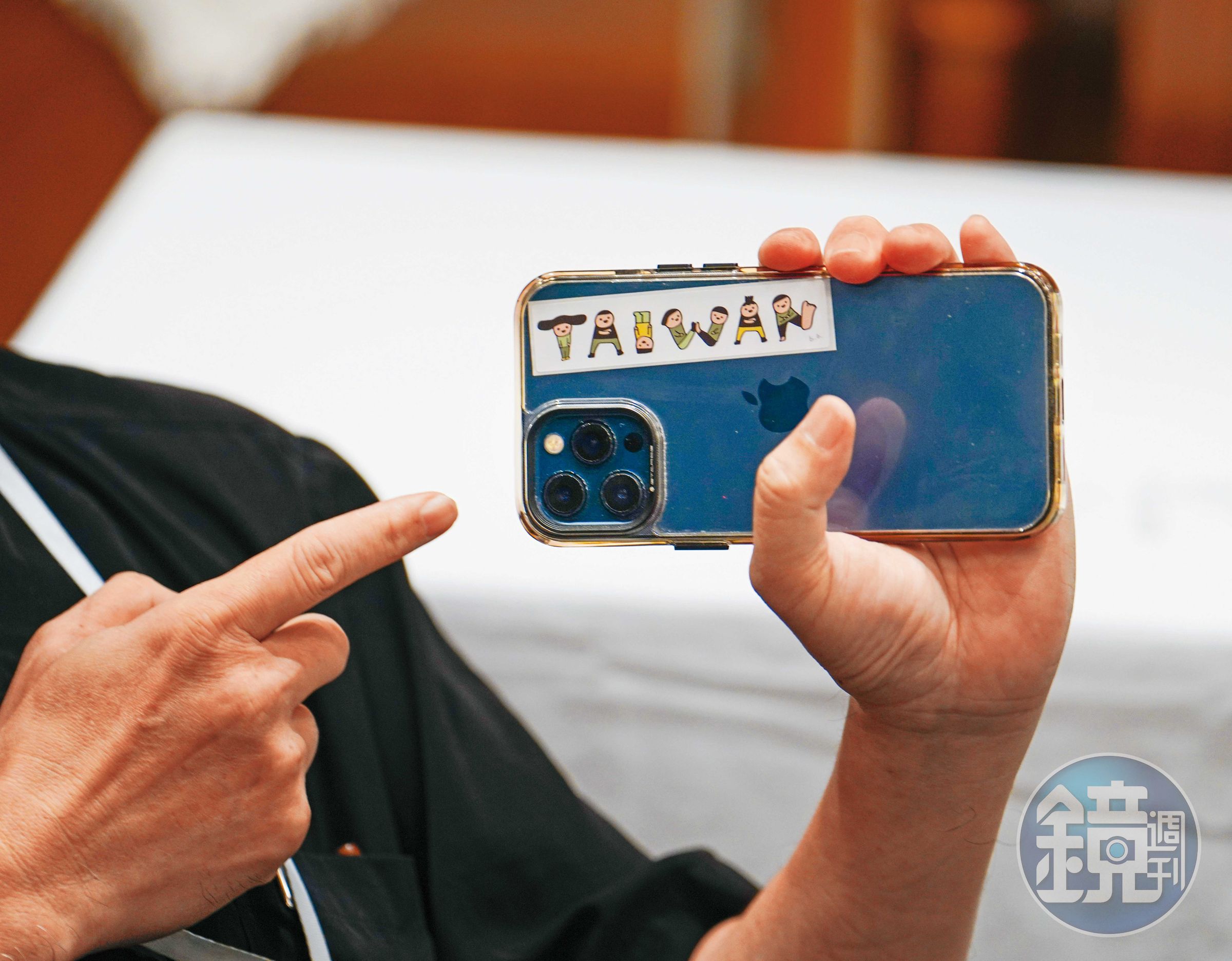 黃春生手機上貼著台派寶寶b.b.設計的貼紙"Taiwan"。