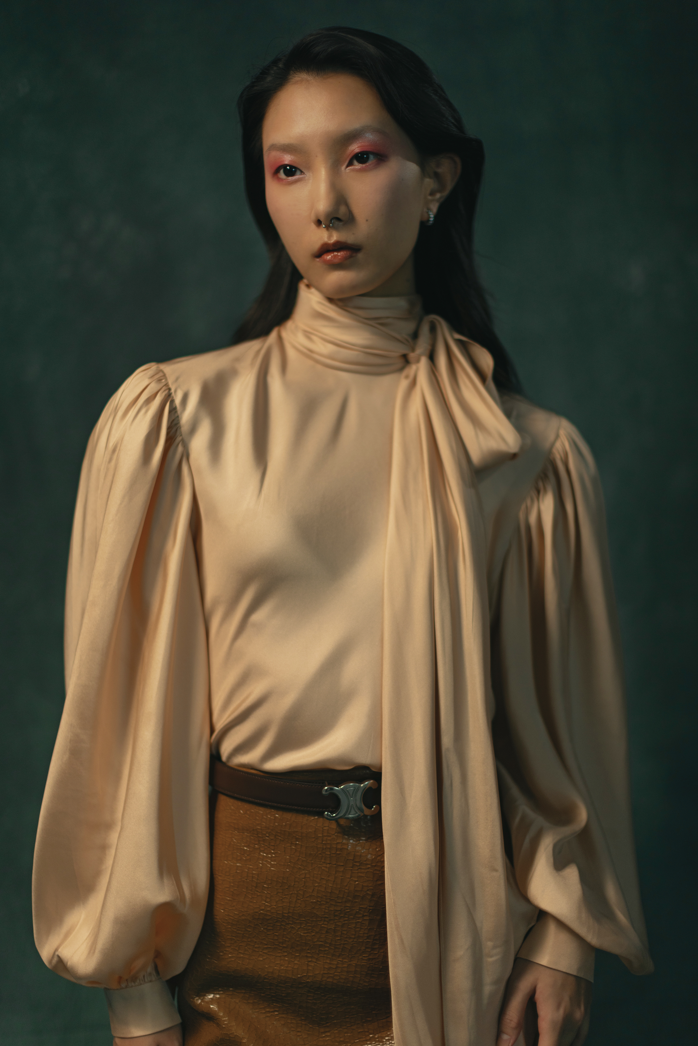 米色絲質襯衫 NT$89,000 by GUCCI／榛果色亮面幾何裂紋皮革中長鉛筆裙 NT$112,000 by GUCCI／TRIOMPHE銀色飾面搭釦及雙面皮帶 NT$24,000 by CELINE