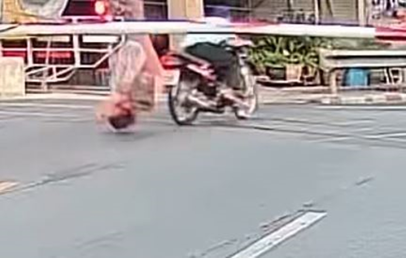 丈夫無視鐵路柵欄降下，強行闖關，導致後座的妻子被柵欄擊中頭部。（翻攝畫面）