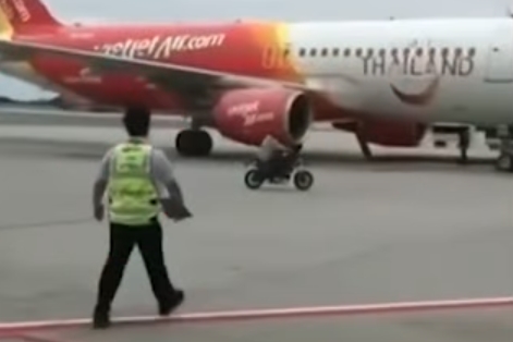 1名男子騎乘機車擅自闖入停放多架飛機的跑道區域,手持疑似武器的不明物體。(翻攝自เรื่องเล่าเช้านี้ 臉書)