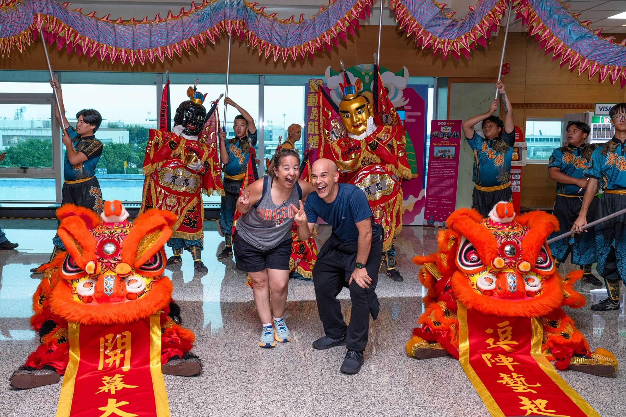 在國際機場巧遇台灣藝陣的國際旅客，與舞獅及三太子等神將陣頭開心合影，留下難忘的文化回憶。（財團法人昇恒昌基金會提供）
