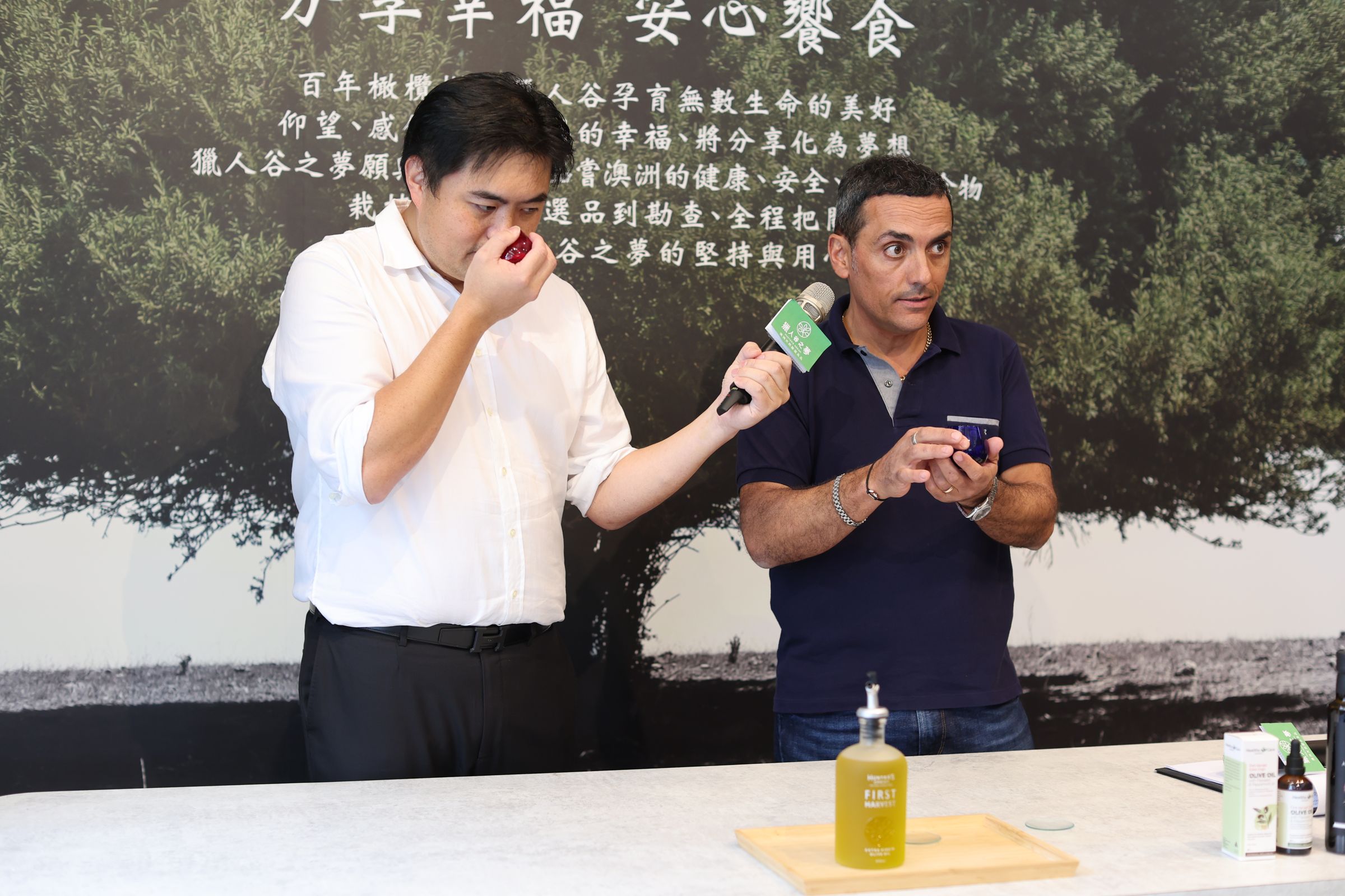 澳洲希爾斯頓的橄欖農莊莊園主人Mauro專程來台教學品油,第一步就是先搓後聞,左為獵人谷之夢執行長Michael。(獵人谷之夢提供)